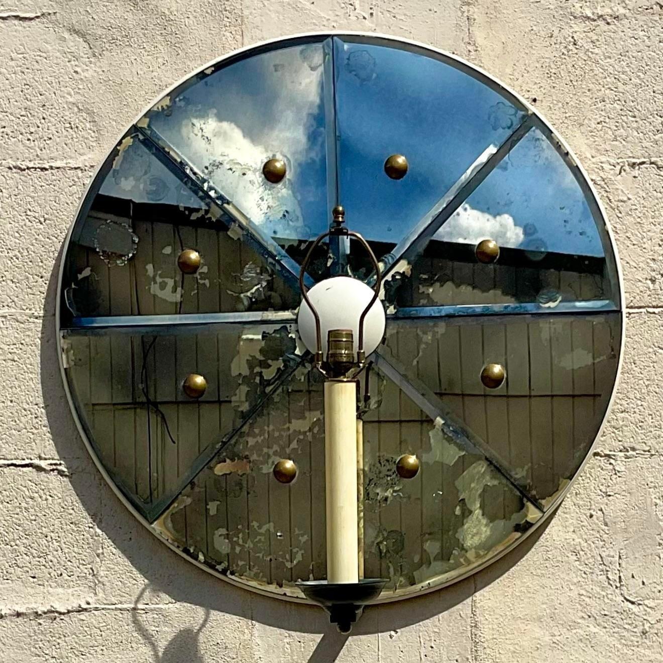 A extraordinary vintage Contemporary wall sconce. Custom made by the iconic Jeffrey Bilhuber. Unmarked. Beautiful Mercury mirror in 8 separate sections. Brushed brass hardware and a single candlestick light fixture. Monumental in size and drama.