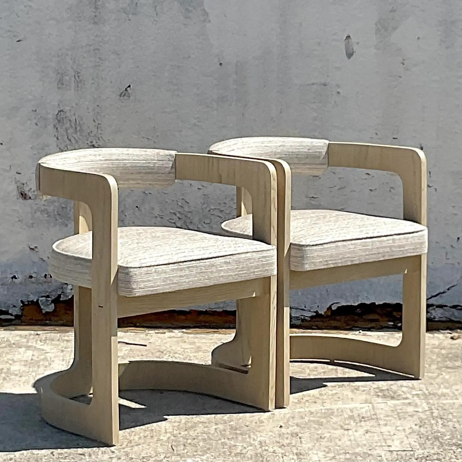 An exceptional pair of vintage Contemporary dining chairs. Made by the legendary Kelly Wearstler. A chic cerused oak frame with burnished brass hardware. Acquired from an amazing Palm Beach estate.