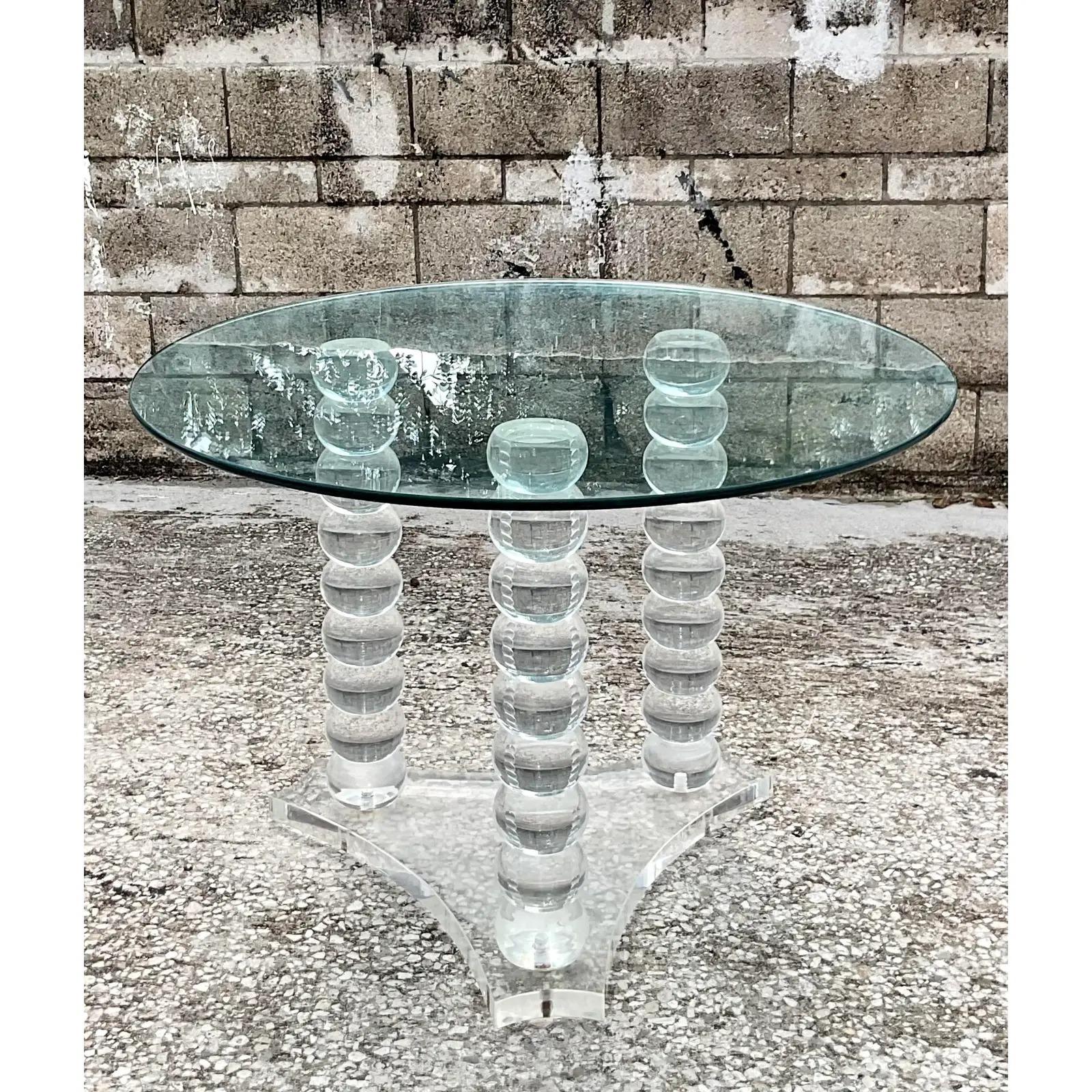 Fantastic vintage lucite dining table. Fab ball bearing design with a thick lucite base. The glass is currently at a 42, but could easily handle up to a 60. Acquired from a Palm Beach estate.