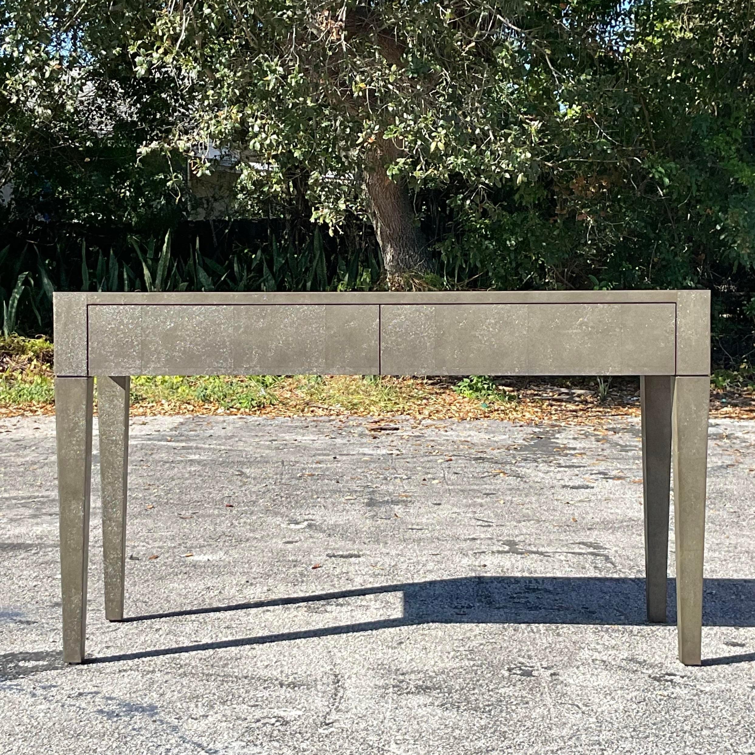 Elevate your workspace with this Vintage Contemporary Writing Desk by Made Goods, showcasing a luxurious faux shagreen finish. This sophisticated piece features clean lines, a sleek profile, and a modern aesthetic that seamlessly blends function