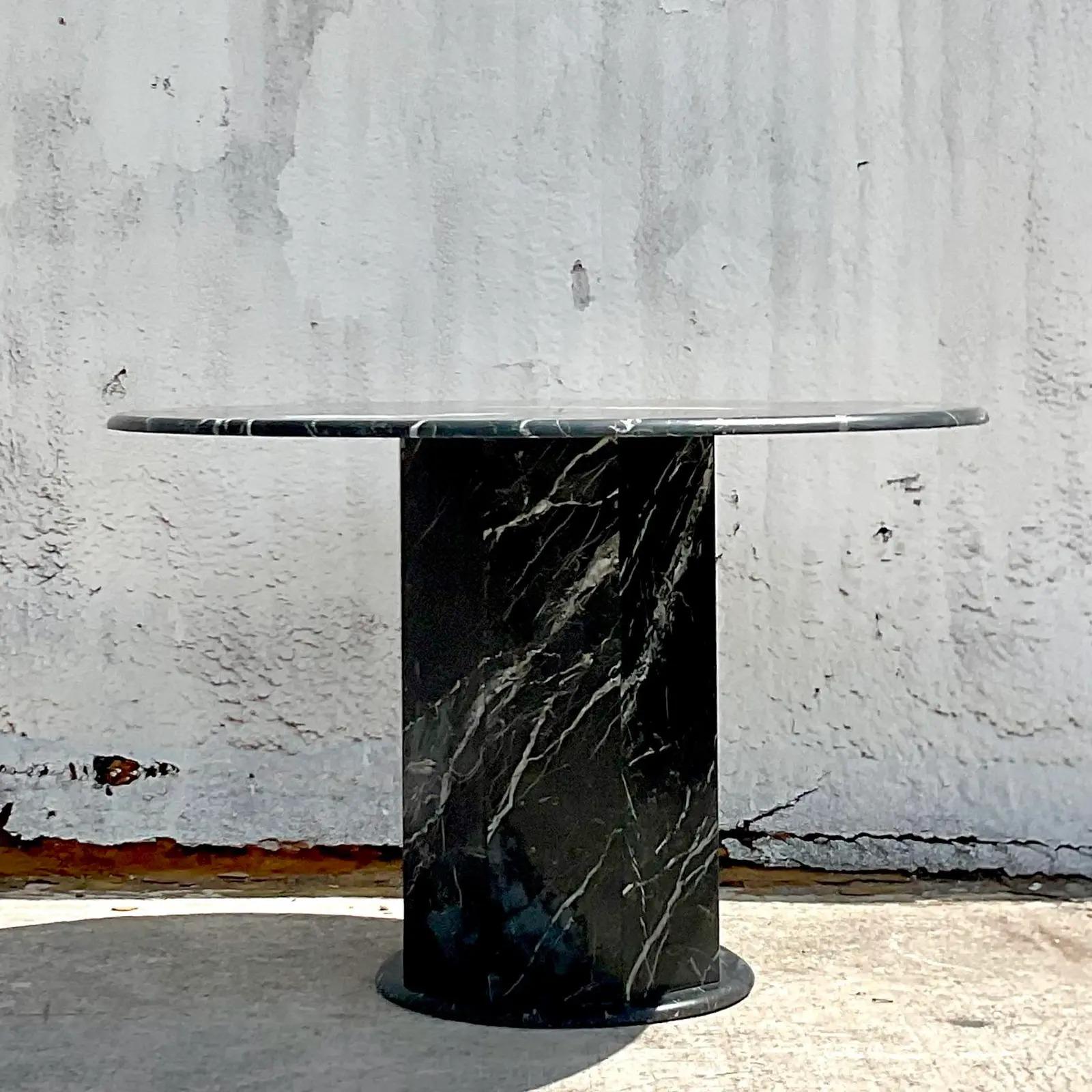 An exceptional vintage Contemporary marble table. A chic black Marquina stone in a matte finish. Octagon pedestal with a round top and a bull none edge. Perfect as a dining table, entry table or game table. You decide! Acquired from a Palm Beach