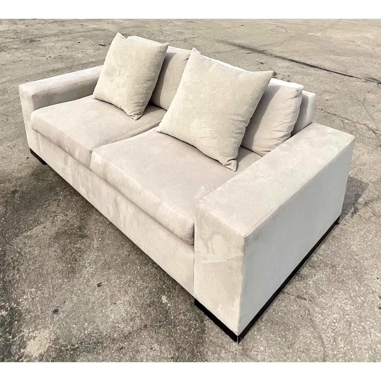 A fantastic vintage Restoration Hardware sofa. The coveted Modena Track Arm design in plush grey velvet. Deep pesetas and plump cushions make this a perfect spot to relax. Rests on wooden plinths. Acquired from a Palm Beach estate.