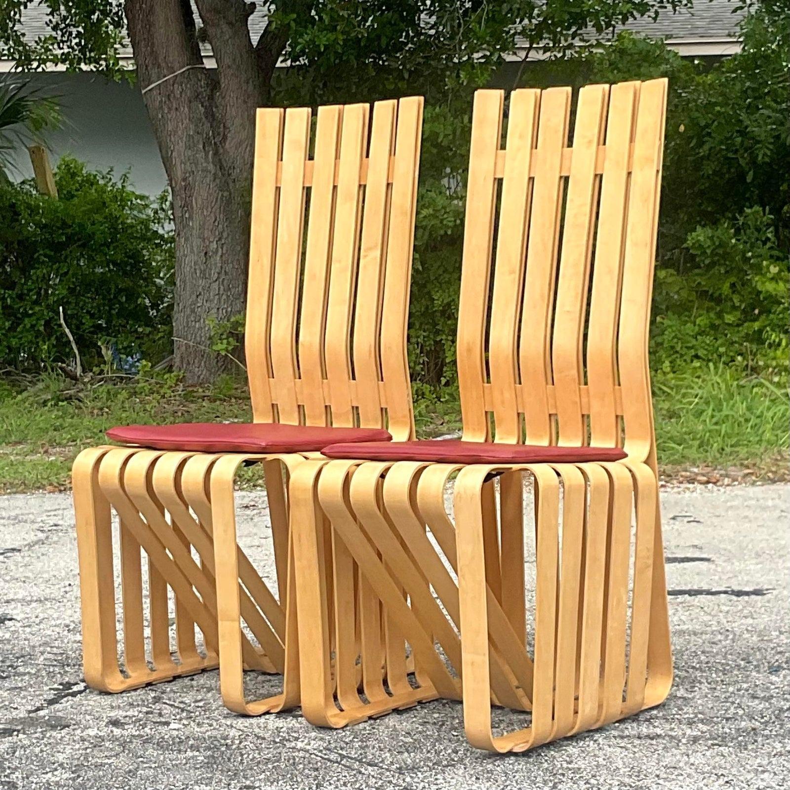 An exceptional pair of vintage Contemporary dining chairs. Designed by the iconic Frank Gehry for Knoll. Striking maple ribbons in a sculptural composition. Padded cushion in a pebble finish. A real collectors find. A matched pair in excellent
