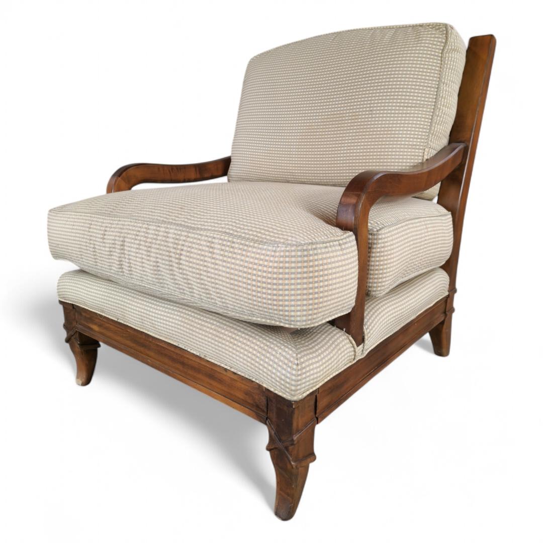 Sillón con brazos tapizado en tela escocesa color crema, con marco de madera, de Sam Moore.

