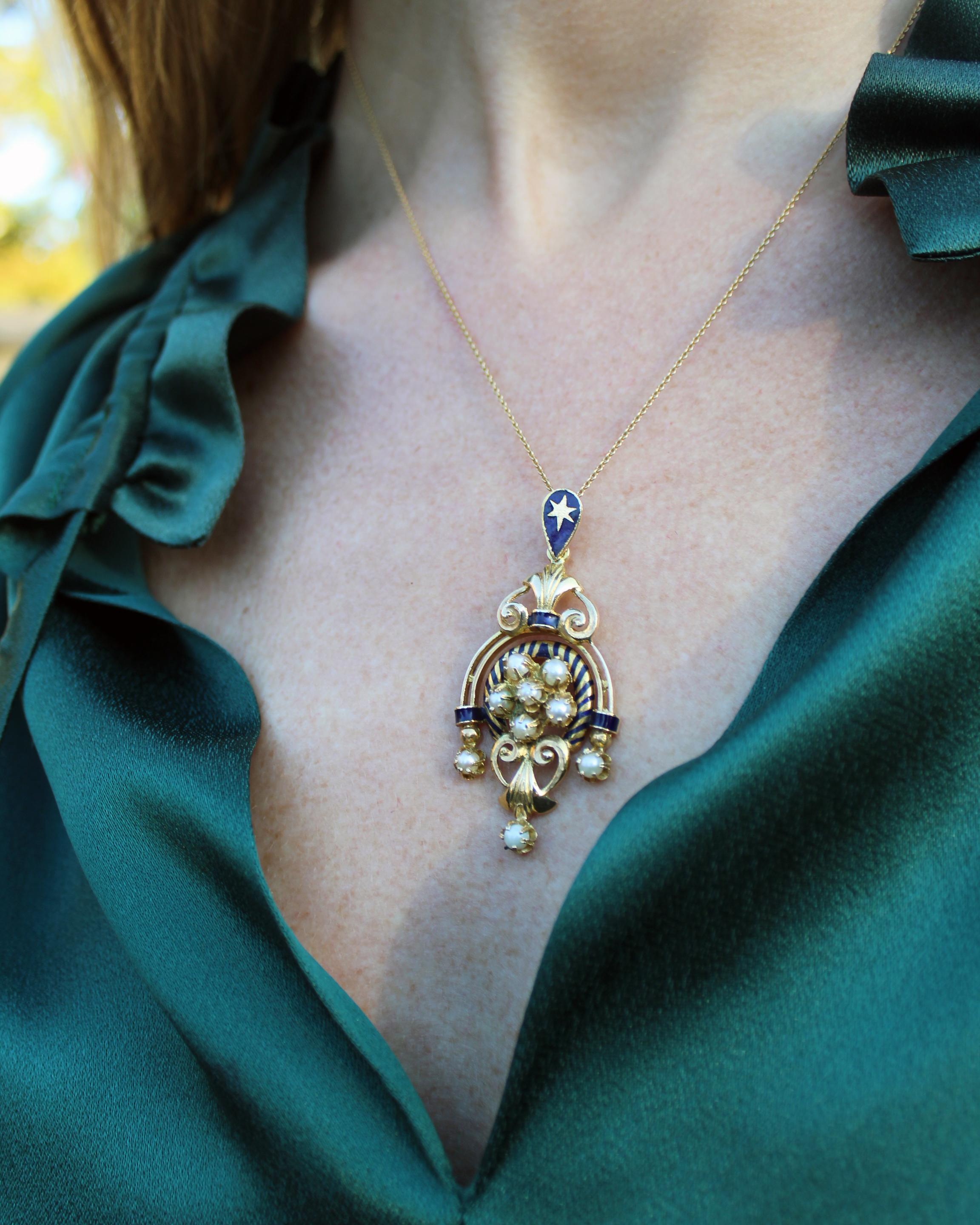This vintage lavalier pendant is an incredibly special piece that will be in your collection and certainly become an heirloom. It features an ornate architectural volute motif, crafted from solid 14k gold with blue enamel work and seed pearls. I