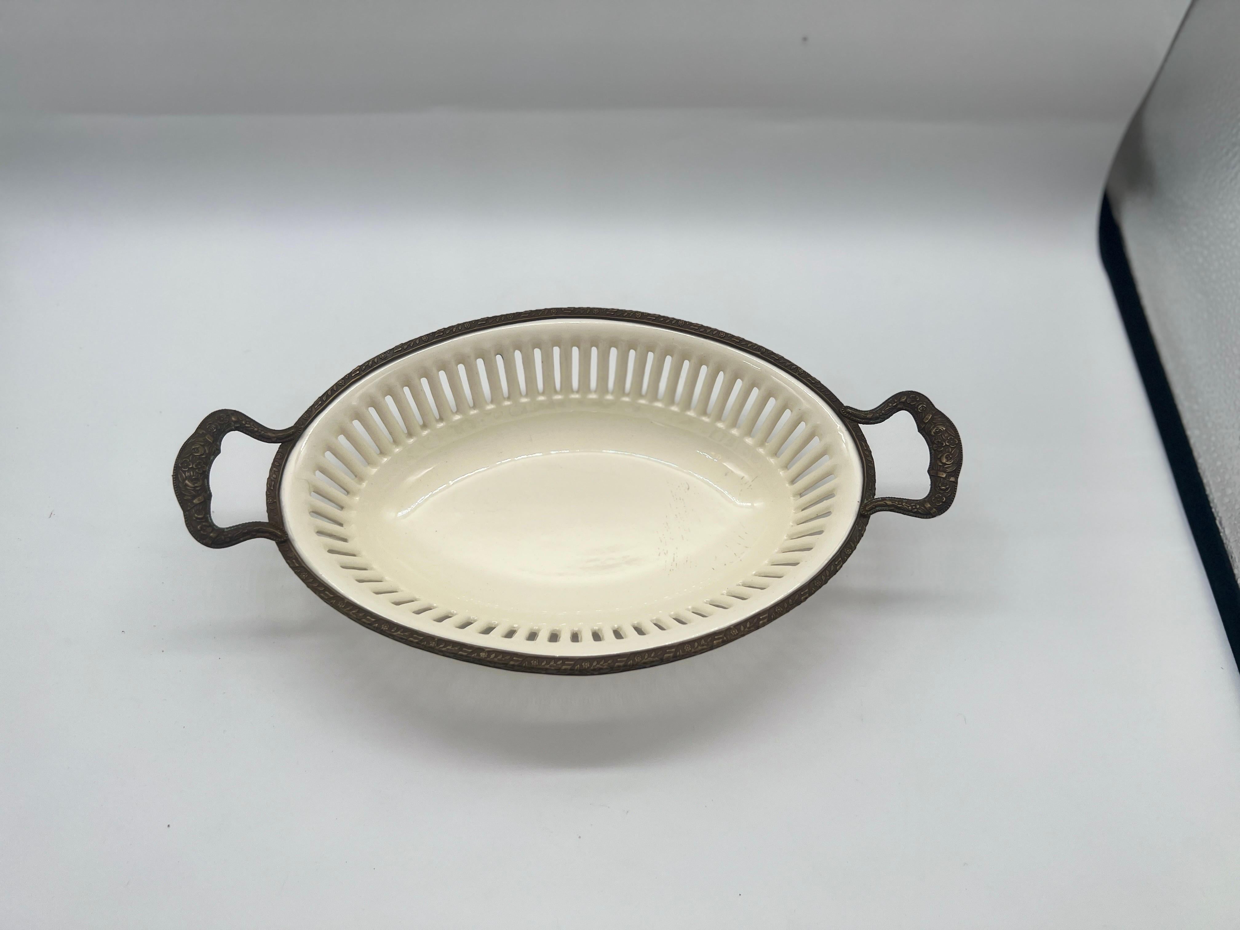 Continental, 20th century.
A traditional creamware basket with pierced body. The bowl is mounted with an engraved ormolu mount. Marked to underside.