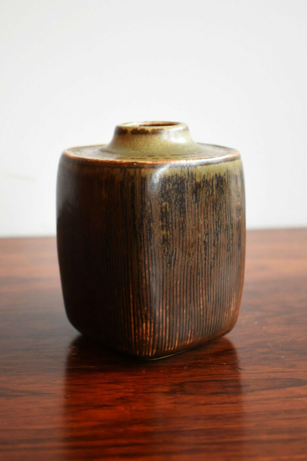 A Copenhagen Pottery ceramic vase with beautiful and intricate textural pattern line detailing. The pot boasts a range of earthy tones, from deep browns to some subtle blue/grey tones, which are accentuated by the grooves and textures within the pot