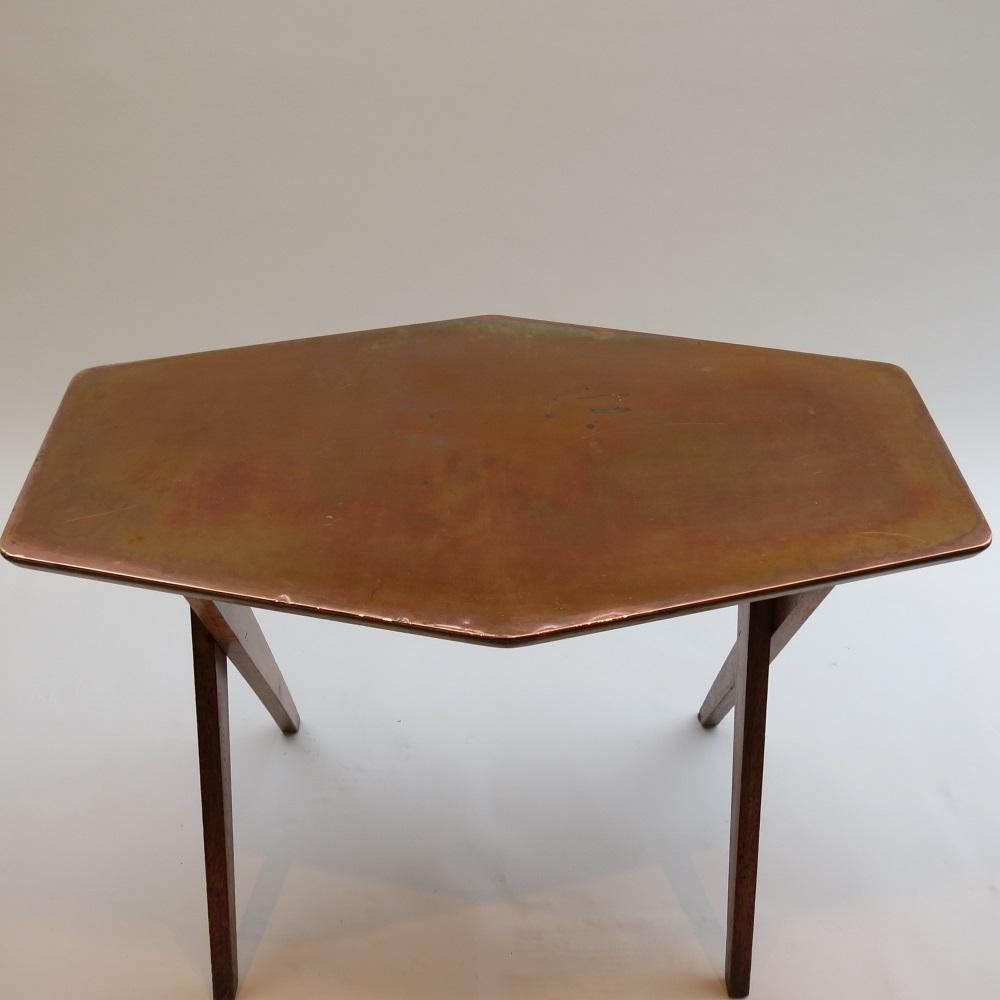 1950s side table made from oak with plywood and copper top. Hand produced in the 1950s. Very nice design with cross over legs and shaped top. In good vintage condition with wonderfully patinated copper; nice color and distressing to the oak