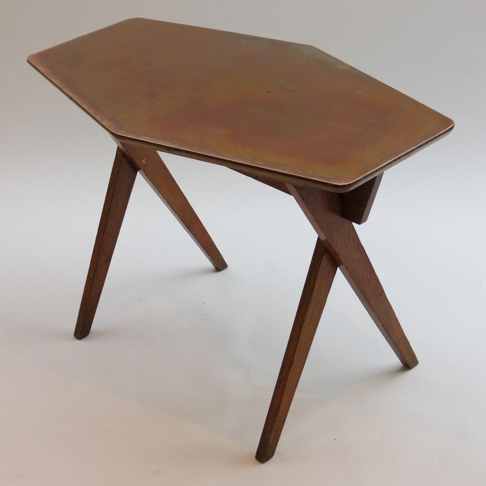 1950s side table made from oak with plywood and copper top. Hand produced in the 1950s. Very nice design with cross over legs and shaped top. In good vintage condition with wonderfully patinated copper; nice color and distressing to the oak
