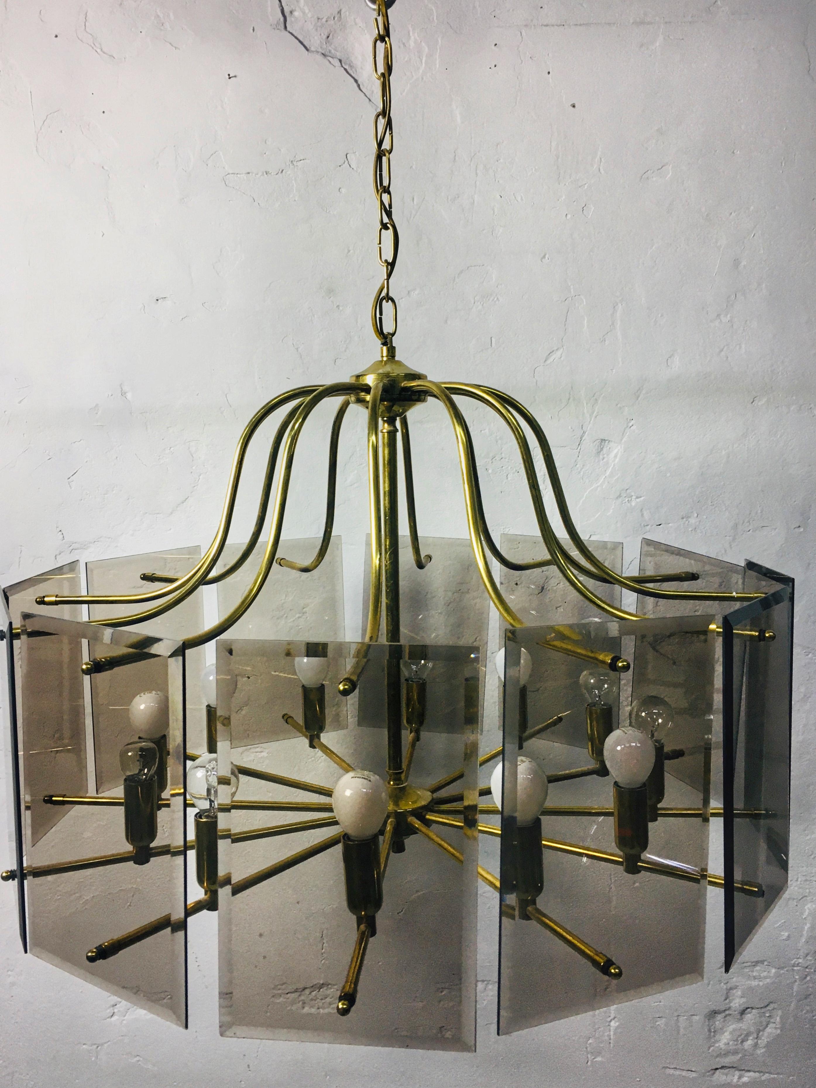 Gold-colored, 12-burner copper chandelier with smoked glass panels with polished edges. Elegant, clean design that provides a pleasant diffused light. 1970s. A rare form.