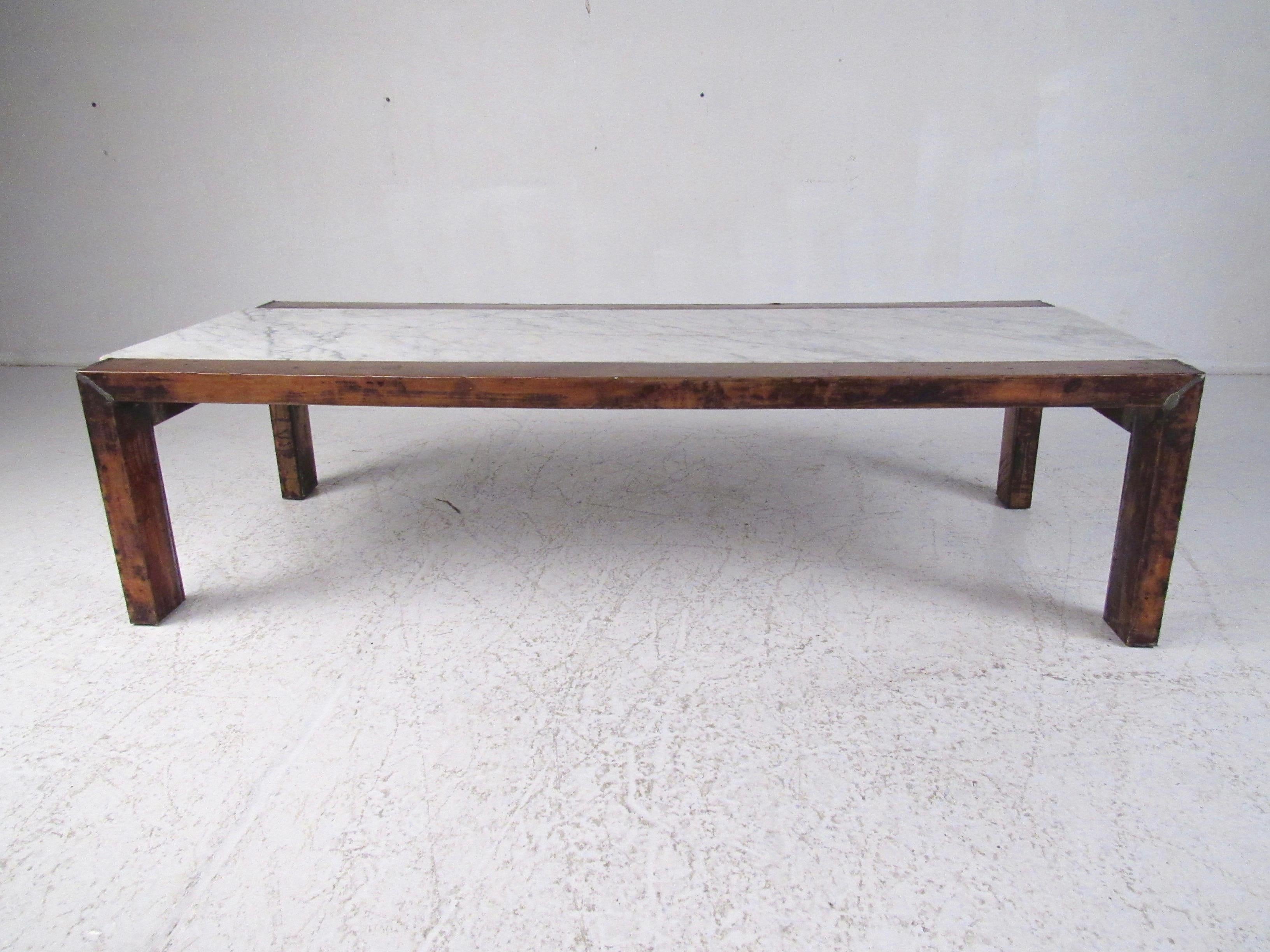 Questo sorprendente tavolino da caffè in stile Mid-Century Modern presenta una struttura in legno duro rivestita in rame patinato vintage. Dotato di un piano in marmo vintage, questo tavolino da cocktail realizzato in studio è un'aggiunta robusta in