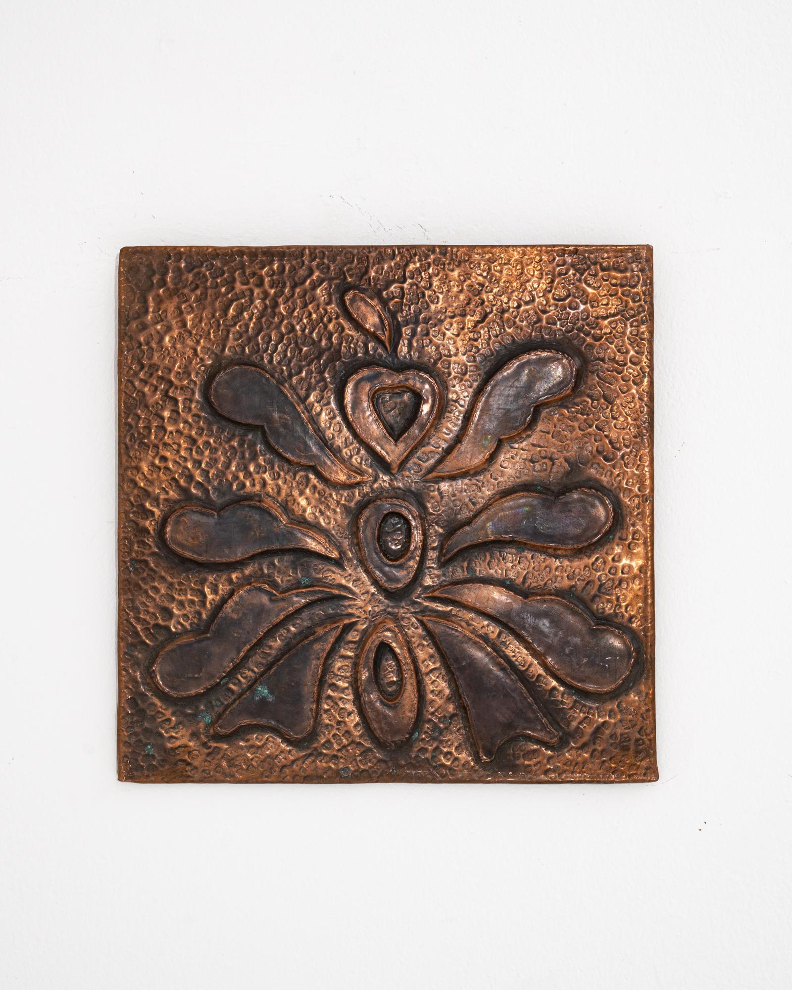 Gráfica y llamativa, esta decoración mural de cobre constituye un acento vintage único. La placa cuadrada está decorada con un símbolo metálico en relieve -abstracto y tipográfico, la forma crea un motivo intrigante. El fondo se compone de marcas