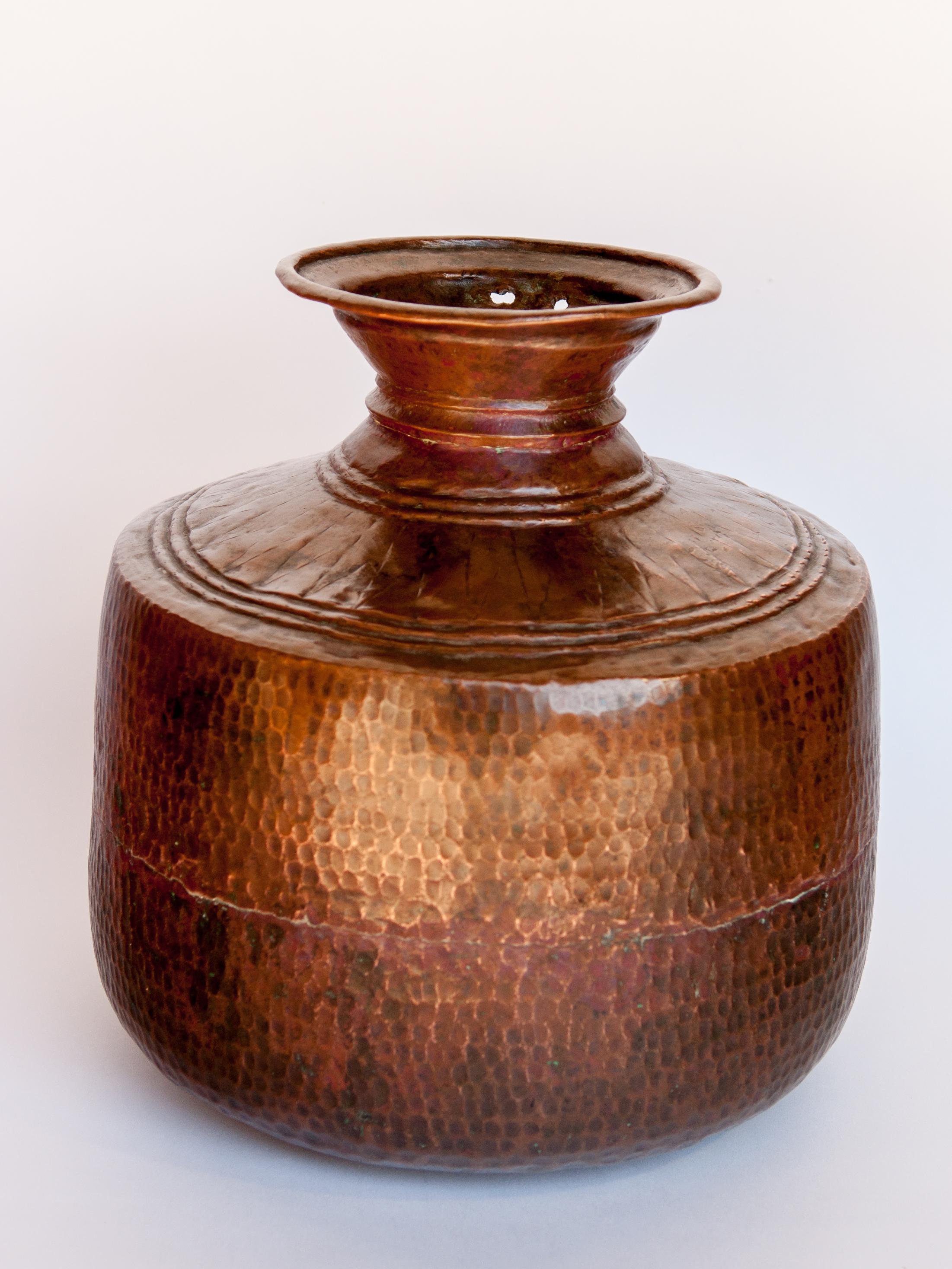 Vintage copper water pot, hand-hammered, from Nepal, mid-20th century.
Water pots such as this were ubiquitous throughout Nepal, in a variety of styles. They were used to transport and store water to and for the household. This piece has a lovely