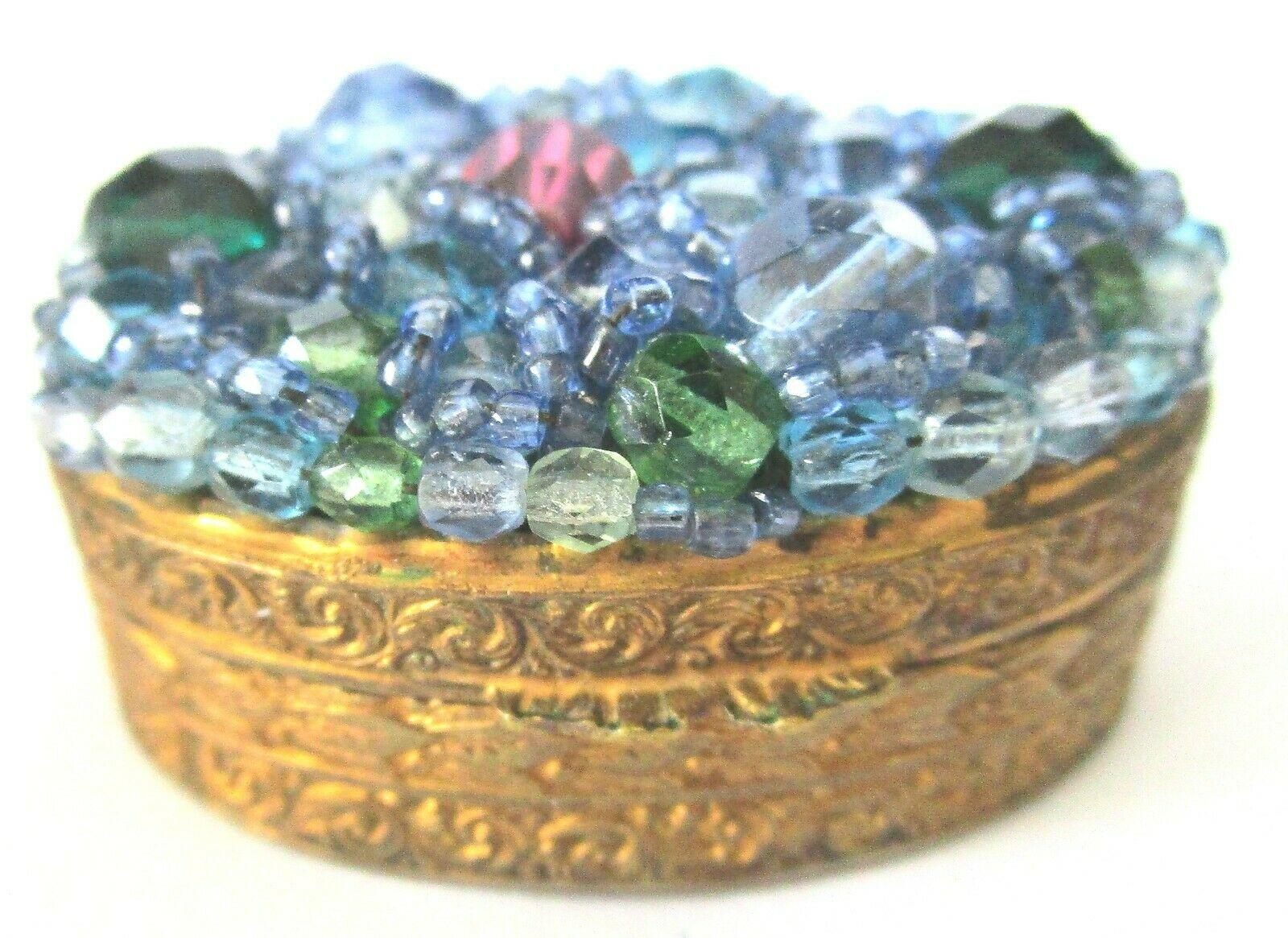 Beautiful rare vintage Coppola e Toppo trinket or pill box. Top encrusted with hand wired crystals, in blues, greens and pink in ornate embossed gold tone design holder. Signed: MADE IN ITALY, however, is a verified Coppola e Toppo piece! Most if