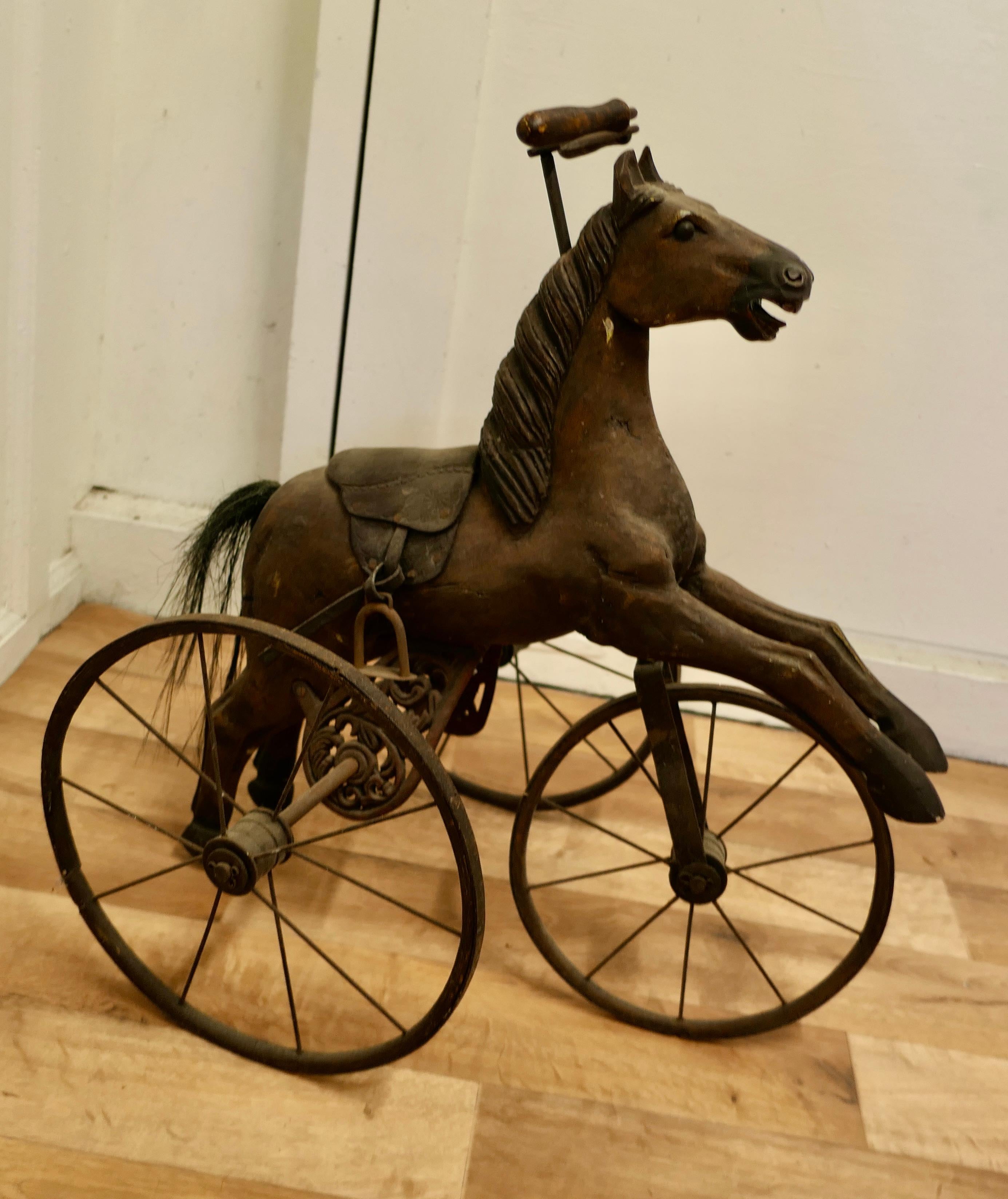 Vintage Copy of a Victorian Toy Tricycle Pedal Horse

A delightful piece, this is a hand made copy, made some 60 years ago of a well known Victorian design, surely an antique of the future
The frame and wheels are made in iron, and the  hand carved