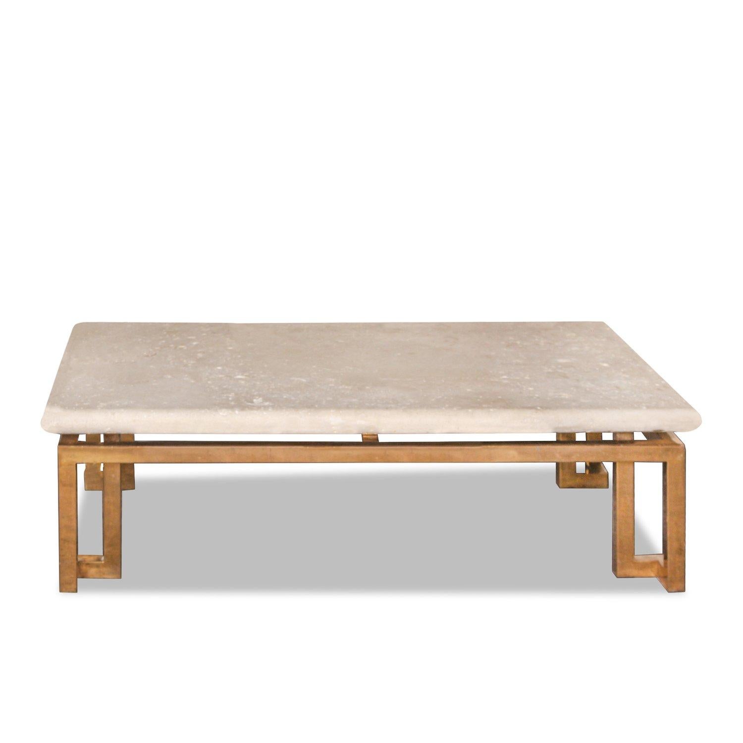 Table basse rectangulaire avec un plateau en pierre naturelle de Coquina à bord arrondi, posé sur une base géométrique en laiton à cadre ouvert. 

Le plateau en pierre présente des inclusions naturelles et des fossiles de coquillages, une signature