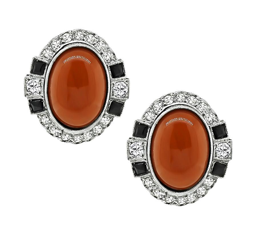 Ein charmantes Paar Ohrringe aus Platin und Gold. Die Ohrringe sind mit schönen Cabochon-Korallen besetzt. Die Korallen werden durch funkelnde Diamanten im Rundschliff mit einem Gewicht von ca. 0,75 ct akzentuiert. Die Farbe dieser Diamanten ist H