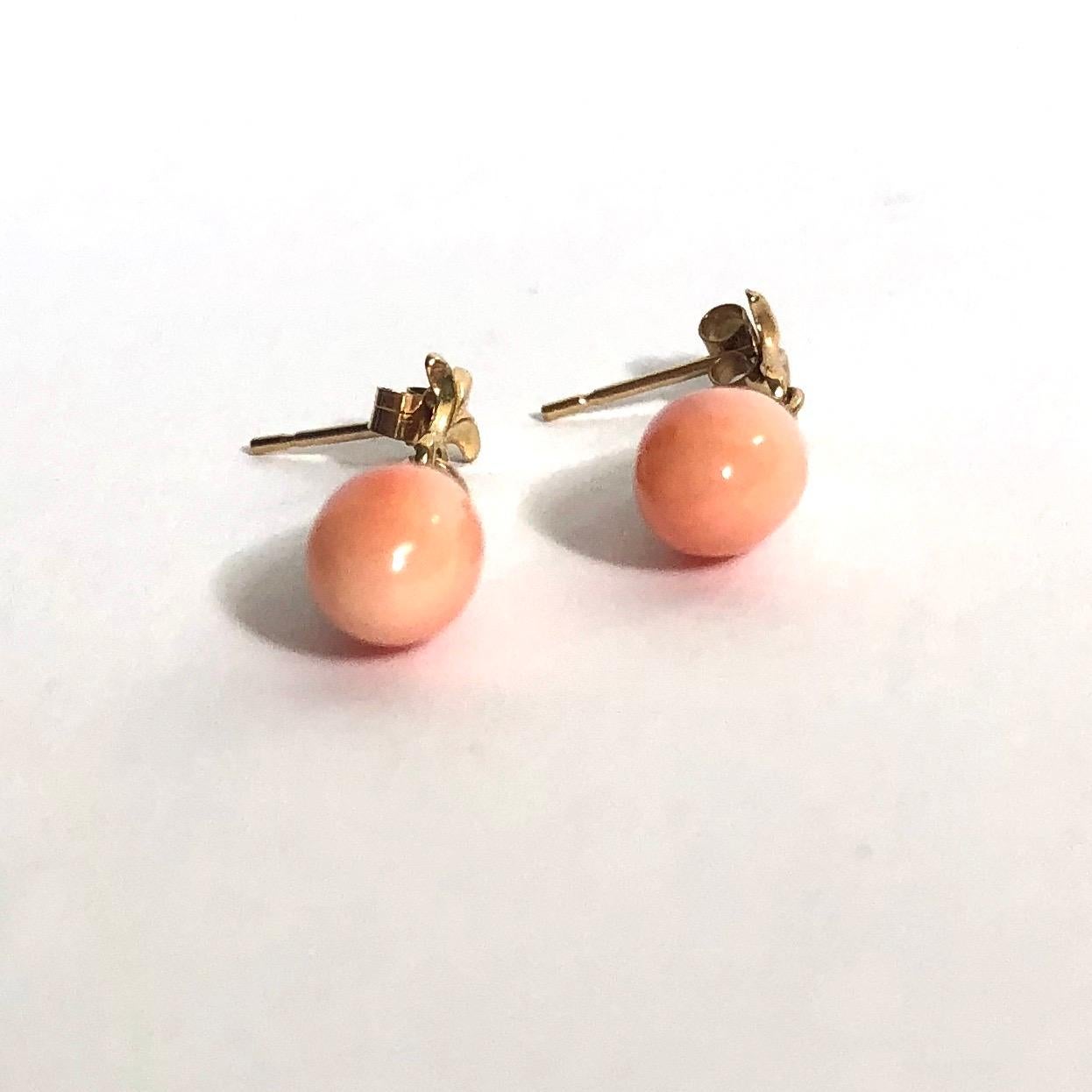 The glossy coral is carved into tear drops and is held in a crown style setting. The drops are on stud earrings. 

Drop From Ear: 25mm

Weight: 1.52g