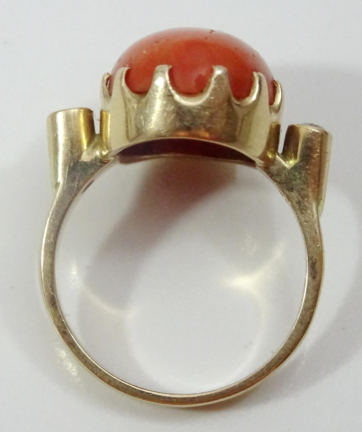 We have for sale a vintage 14 karat gold ring  ( clearly hallmarked )
 The Ring is set with a  striking somewhat between Solomon and Ox Blood red Italian oval Coral measuring 12.5 x 16 mm,. 
Framing the Coral on each side in high cup settings are