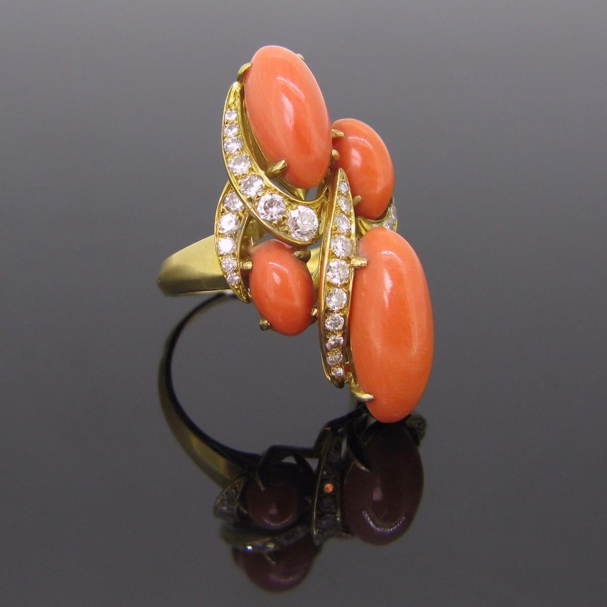 A beautiful coral and diamonds ring. This one was perfectly handcrafted in 18kt yellow gold and adorned with 4 beads of polished corals. These are in very good vintage condition. They have a beautiful reddish orange color. The largest bead is 17,78
