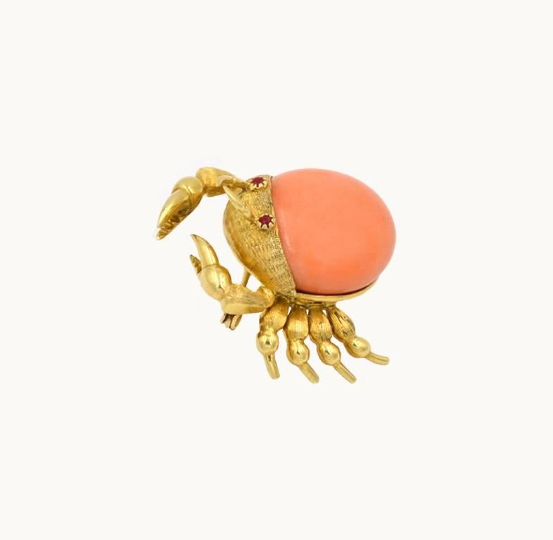  A vintage crab brooch in 18 karat yellow gold from circa 1960.  This brooch features a coral cabochon as the crab body with articulated detail of the crab showing 10 legs in textured gold.  A very cute and well-made piece of jewelry!

This brooch