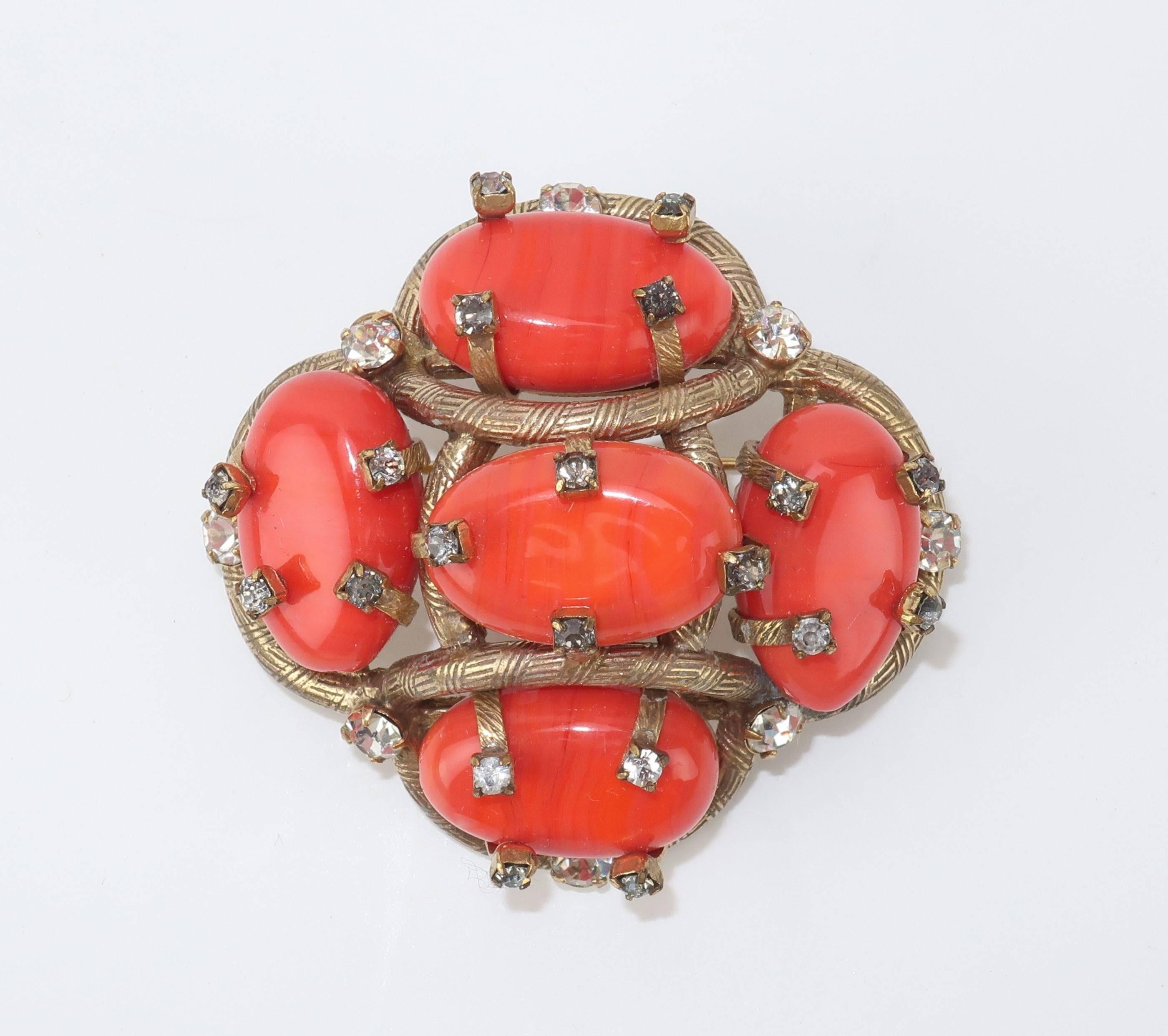 Rings of gold tone incised metal are braided with crystal rhinestones to create a beautiful frame for vibrant coral glass in this vintage brooch.  The straight pin and safety clasp work well to keep the brooch in place ... there is a slight bend to