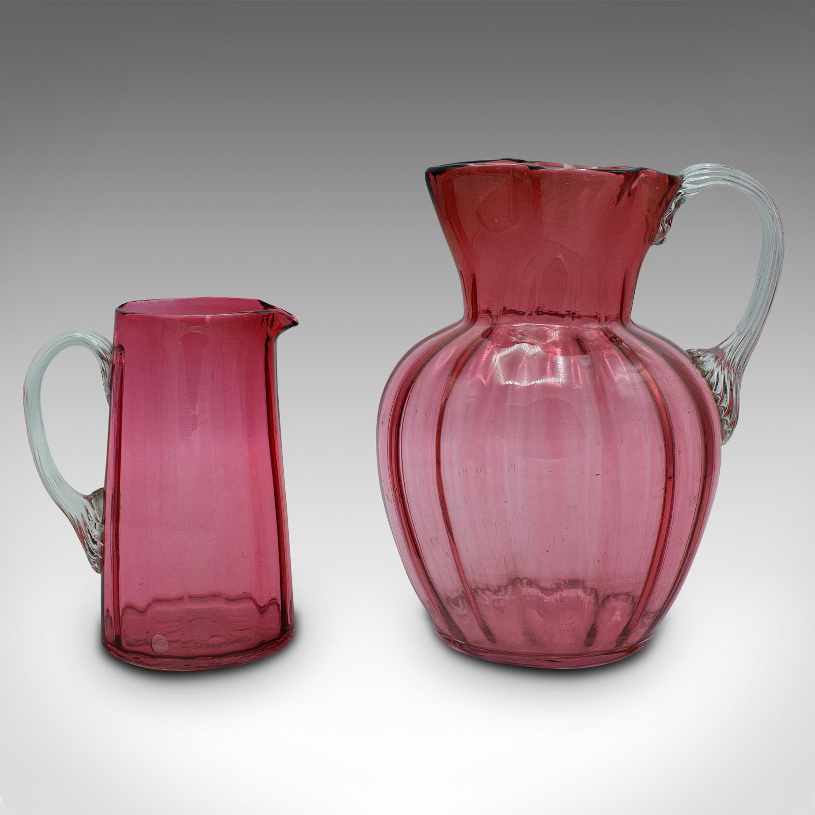 This is a vintage cordial mixer set. An English, cranberry glass pouring jug duo, dating to the early 20th century, circa 1930.

Add colour and flair to a summer drinks gathering
Displays a desirable aged patina and in good order
Bright