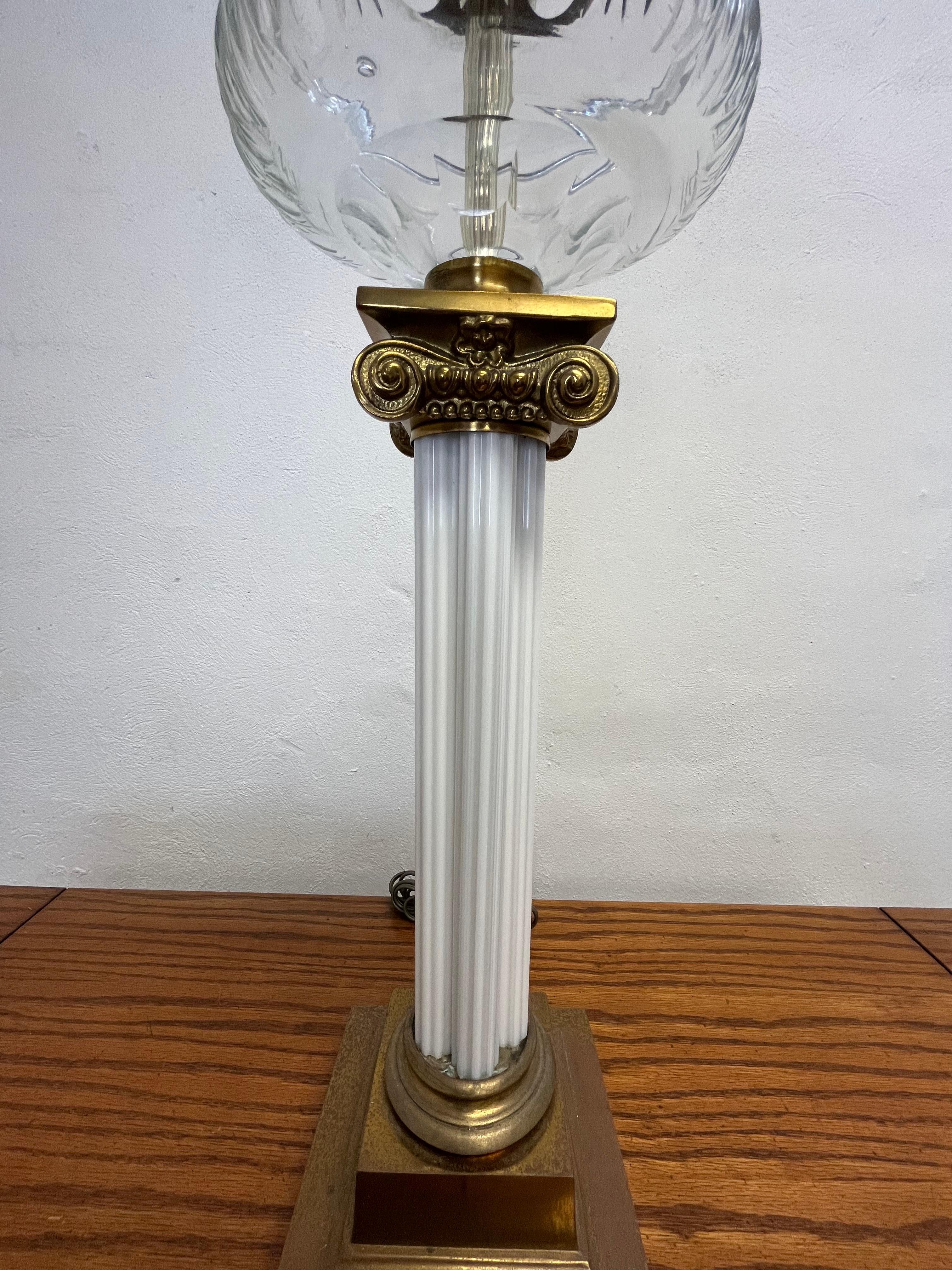 Bellissima lampada a olio a colonna corinzia. Unico fusto a colonna in vetro rigato con grazioso capitello corinzio e base a plinto in ottone. Serbatoio dell'olio in vetro tagliato e moderatore in filigrana. 
