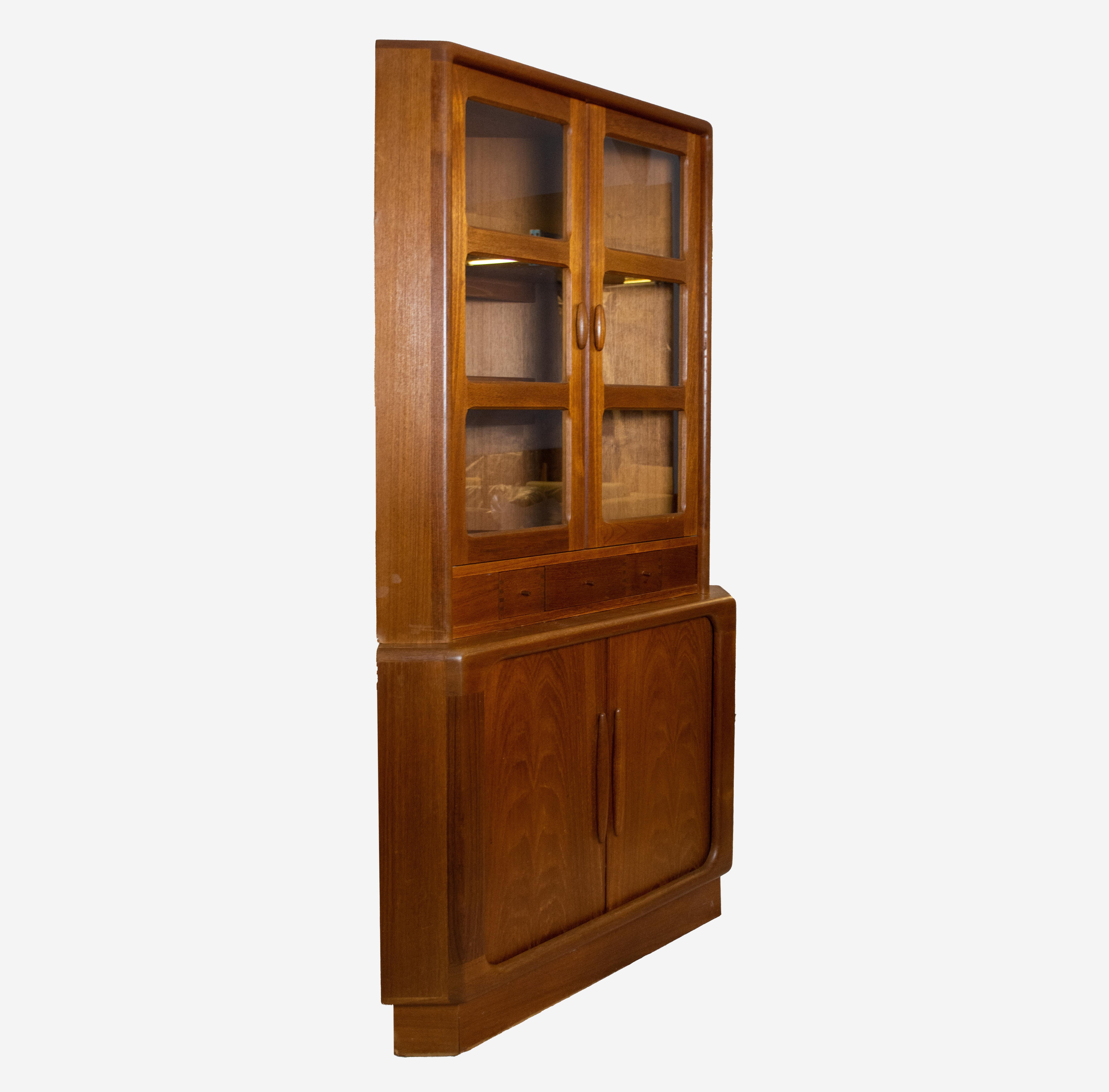 Dieser Vintage-Eckschrank aus Teakholz wurde in den 1970er Jahren von Dyrlund in Dänemark hergestellt. Es gibt viele elegante Details, die man an diesem Artikel schätzen kann. Der obere und der untere Schrank sind zwei separate Teile. Der