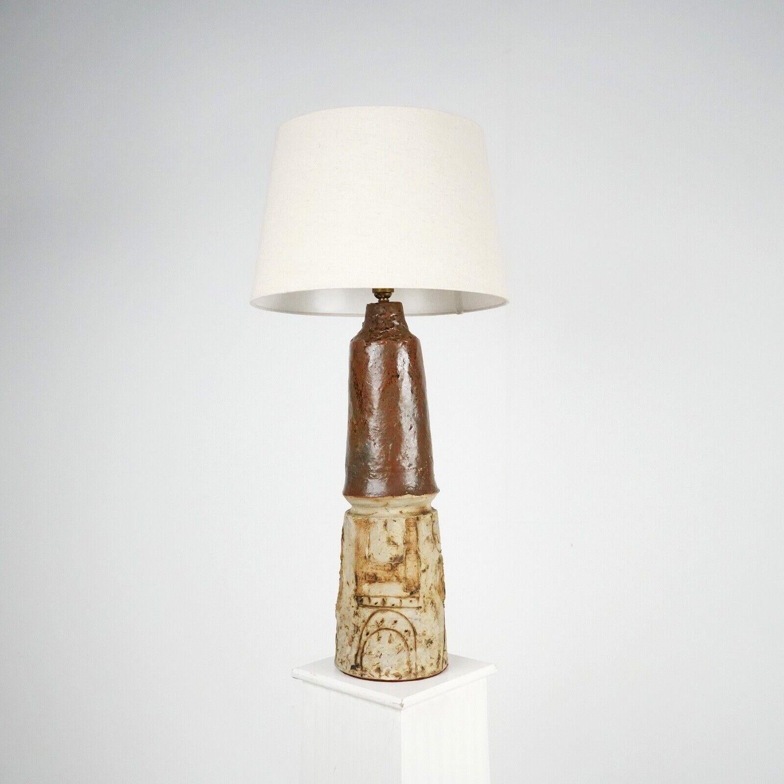 A handcrafted studio ceramic table lamp with sculptural design and natural form decoration. A dark brown glaze at the top if the base which is then mirrored in the decoration designs at the bottom which has a Bernard Rooke look about them.