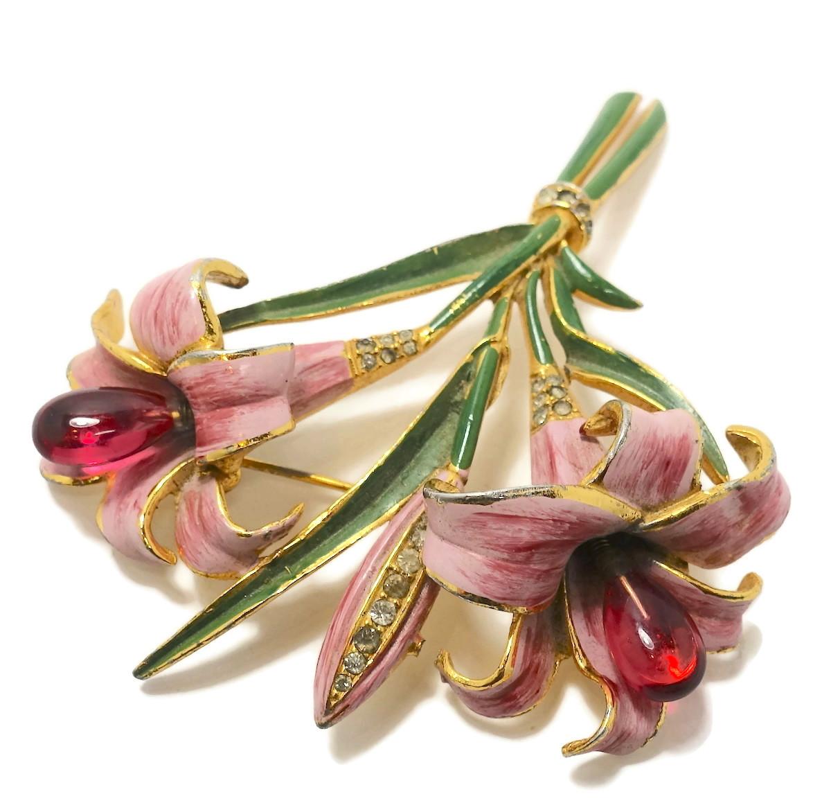 Although this gorgeous brooch is unsigned … it does have the look of a vintage Coro. This trembler brooch has red cabochon glass trembler buds coming out of pink enameled flowers. The leaves are green enamel with clear crystal accents in a gold tone