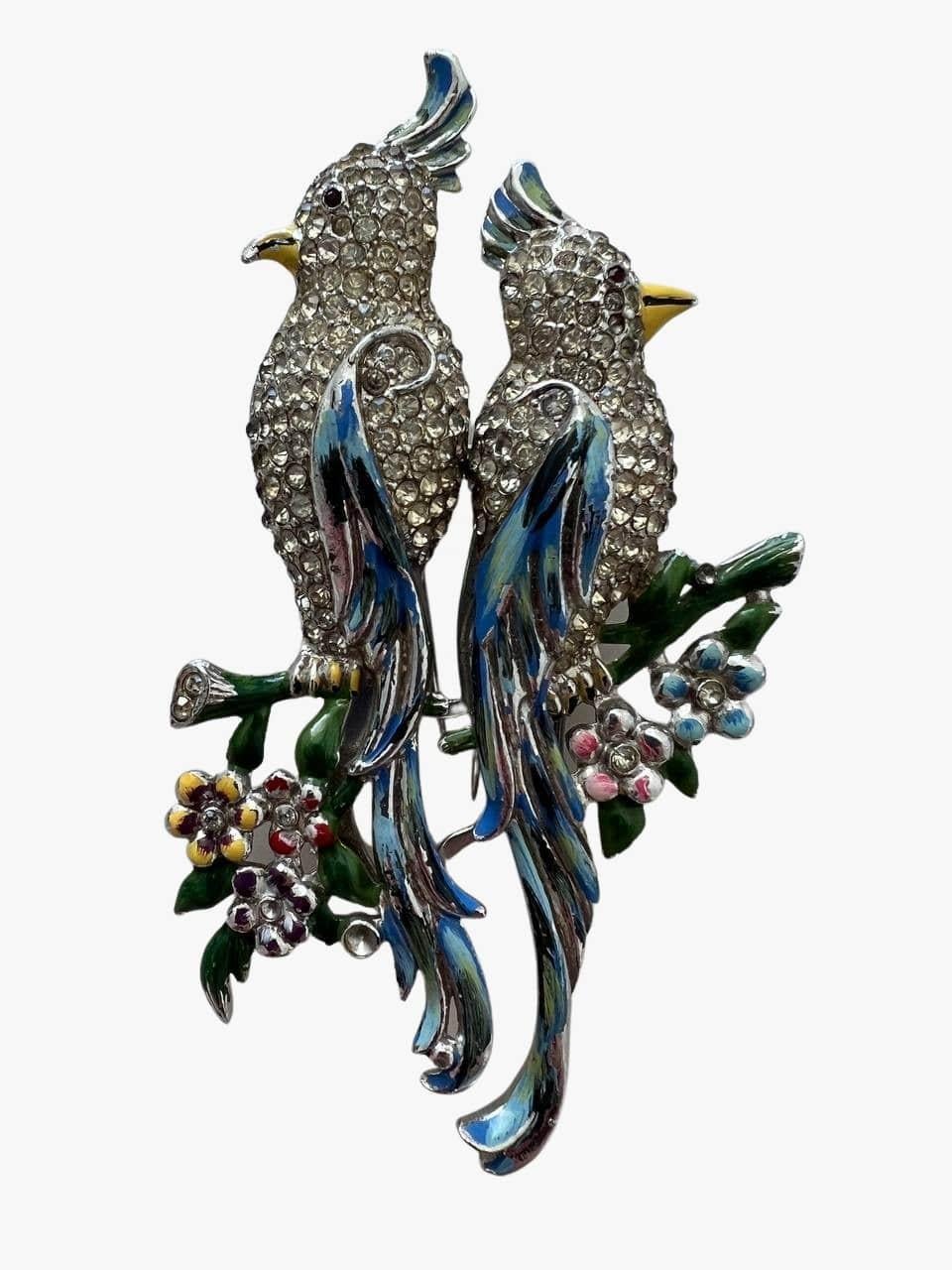 Vintage iconic brooch by Coro features two parrots on a tree branch. Lavishly decorated with rhinestones and accented with colorful enamel details. 
The base metal: sterling silver. The brooch also has fur clips. 
Signed: Coro Duette
AT: 1798867