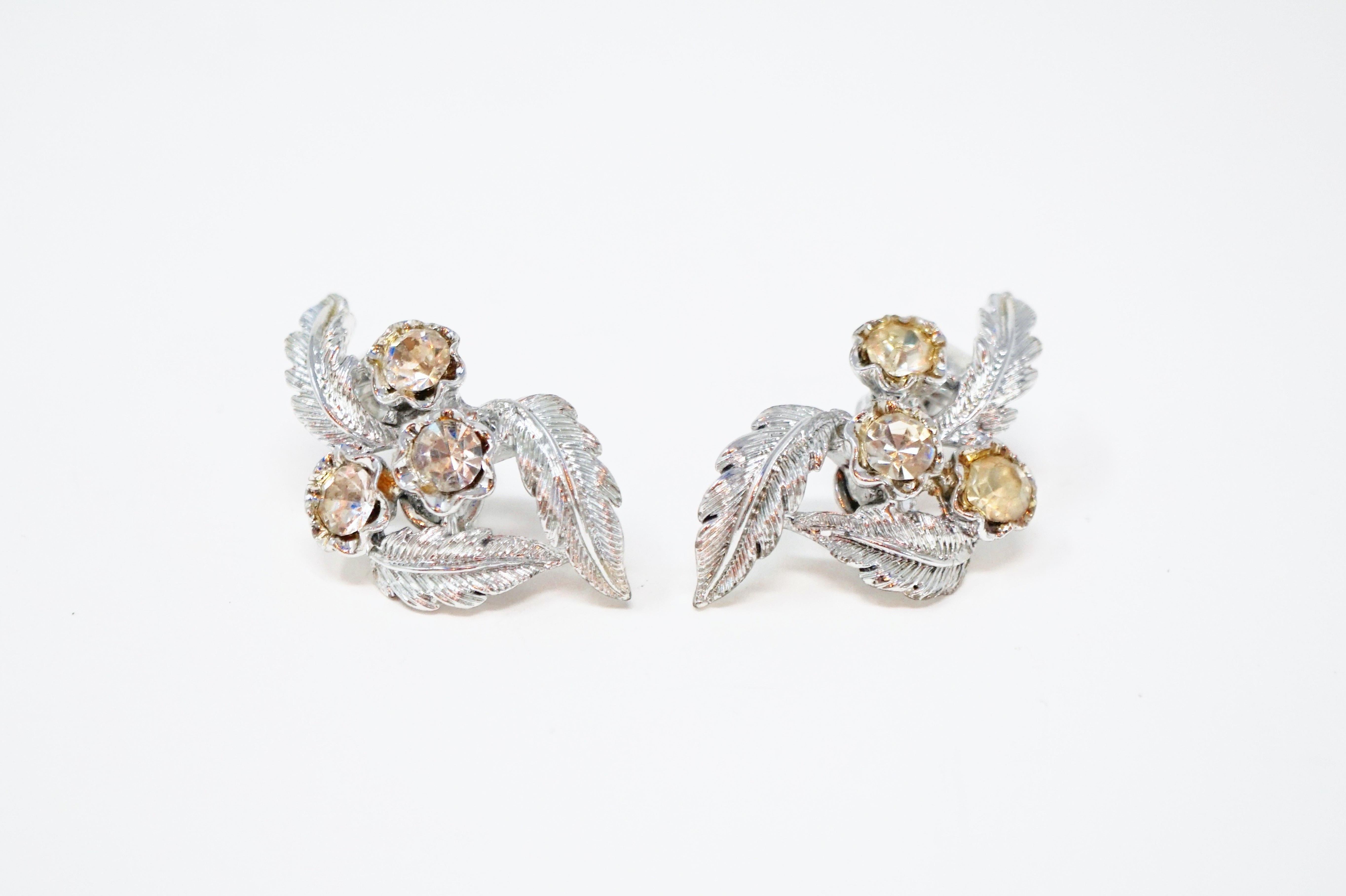 These gorgeous silver tone rhinestone leaf motif clip-on earrings by Coro, circa 1950s, are absolutely dreamy. Rhodium plating and high quality crystal rhinestones will make your ears sparkle and shine! A wonderful 