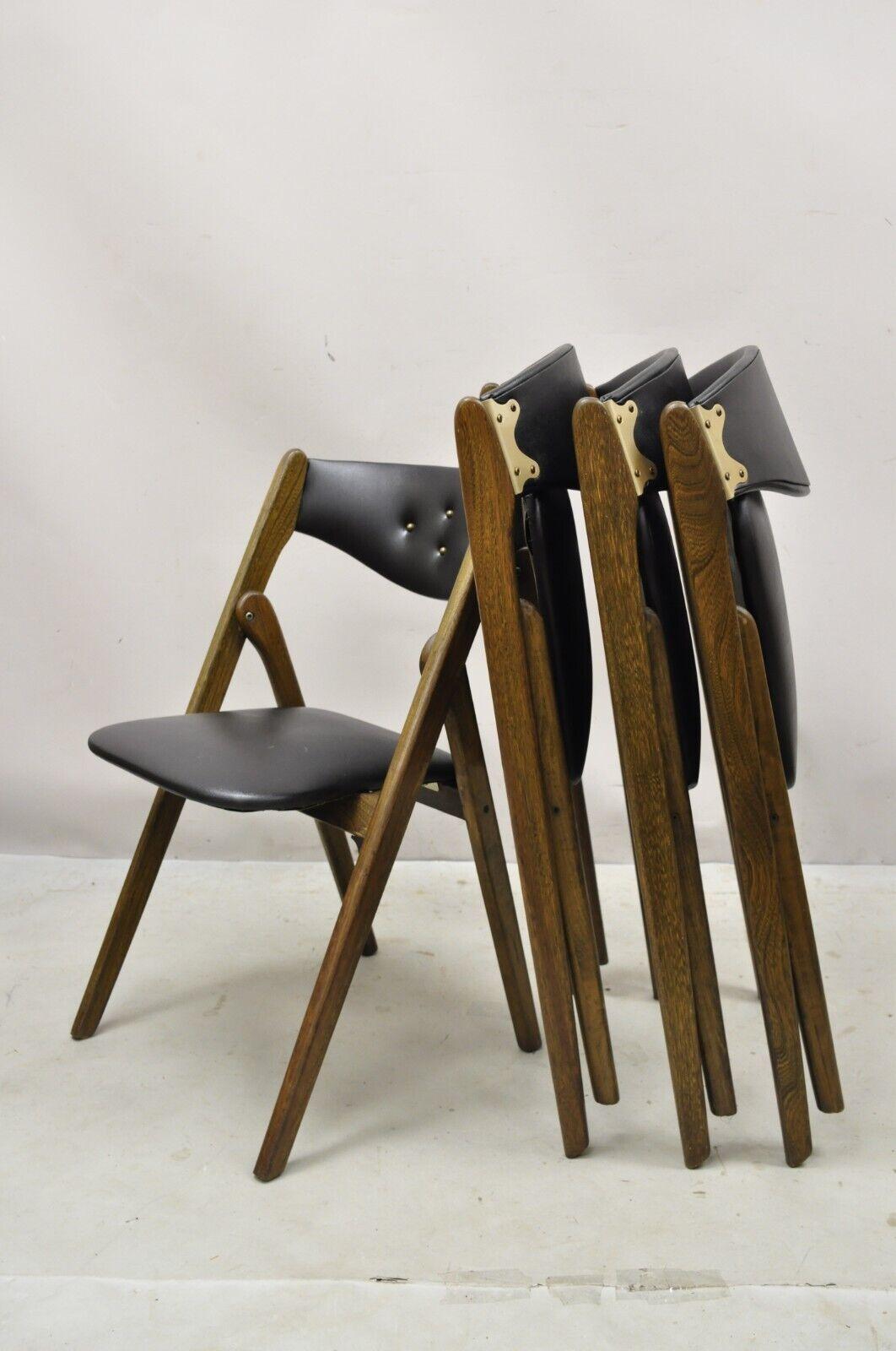 Vintage Coronet wonderfold black vinyl wooden folding game chairs - set of 4. Item features (4) folding chairs, black vinyl upholstery, tufted backrests, solid wood frames, very nice vintage set, sleek sculptural form. Circa mid-20th