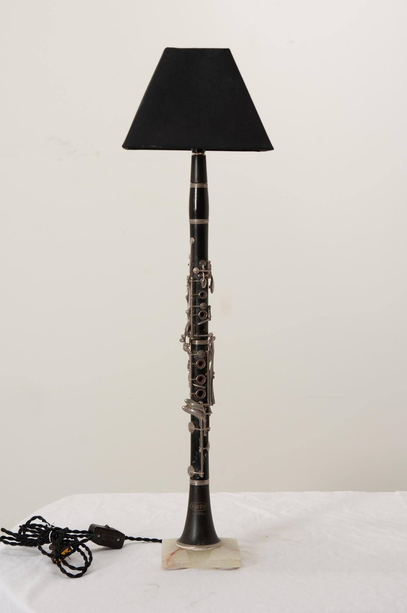 Une clarinette Corton vintage fabriquée en Tchécoslovaquie et recyclée en une fabuleuse lampe de table montée sur une belle base en onyx avec un abat-jour vintage en soie noire. La clarinette montre les signes d'un instrument de musique très aimé et