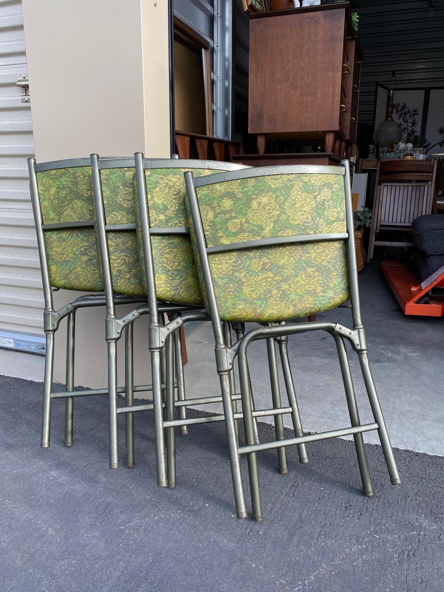 4 metal avocado green frame folding chairs for your kitchen table or additional seating in your home. Original vinyl seat and back covers in a green floral pattern. The chairs are strong and sturdy. Unusual find! Made in the USA.