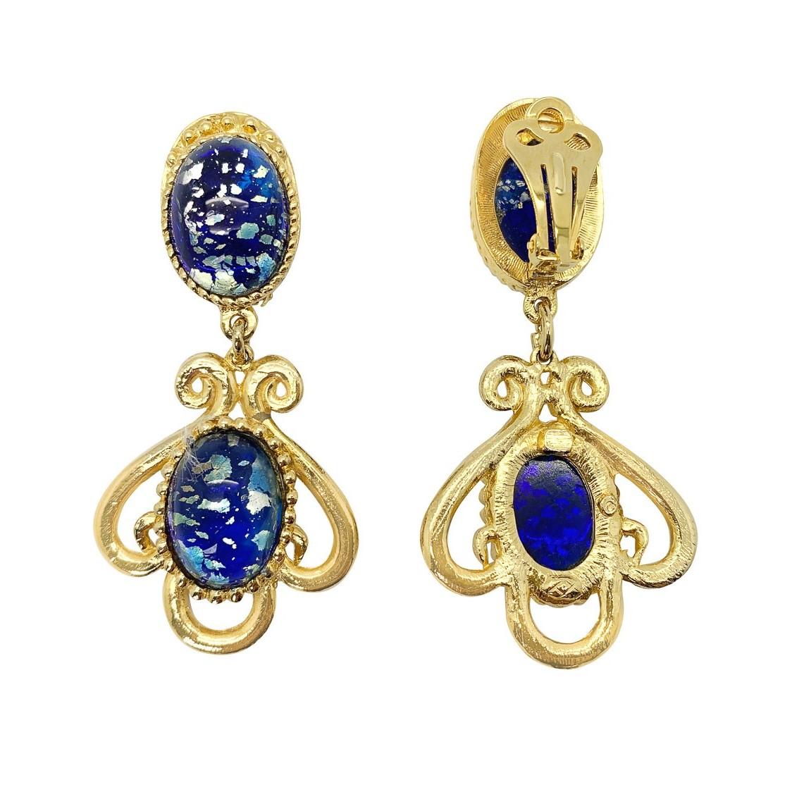 An ultra pretty pair of Vintage Cosmic Glass Earrings. Featuring elaborate golden mounts set with large and captivating glass cabochon stones radiating a cosmic feel.

Vintage Condition: Very good without damage or noteworthy wear.
Materials: Gold