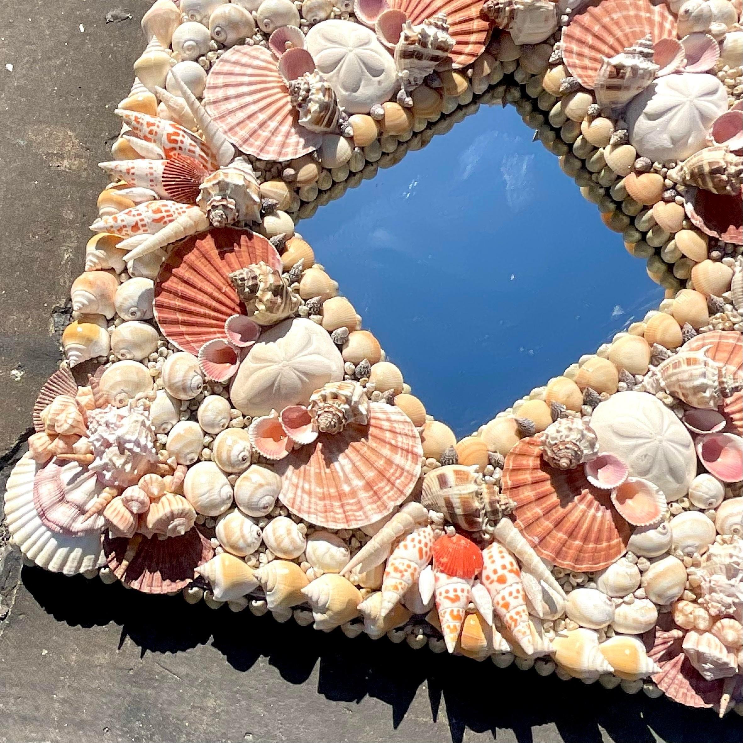 Embrace the essence of coastal charm with this vintage artisan shell mirror, meticulously crafted in the heart of America's shoreline culture. Each shell intricately placed reflects the artisanal dedication to capturing seaside beauty, making it a