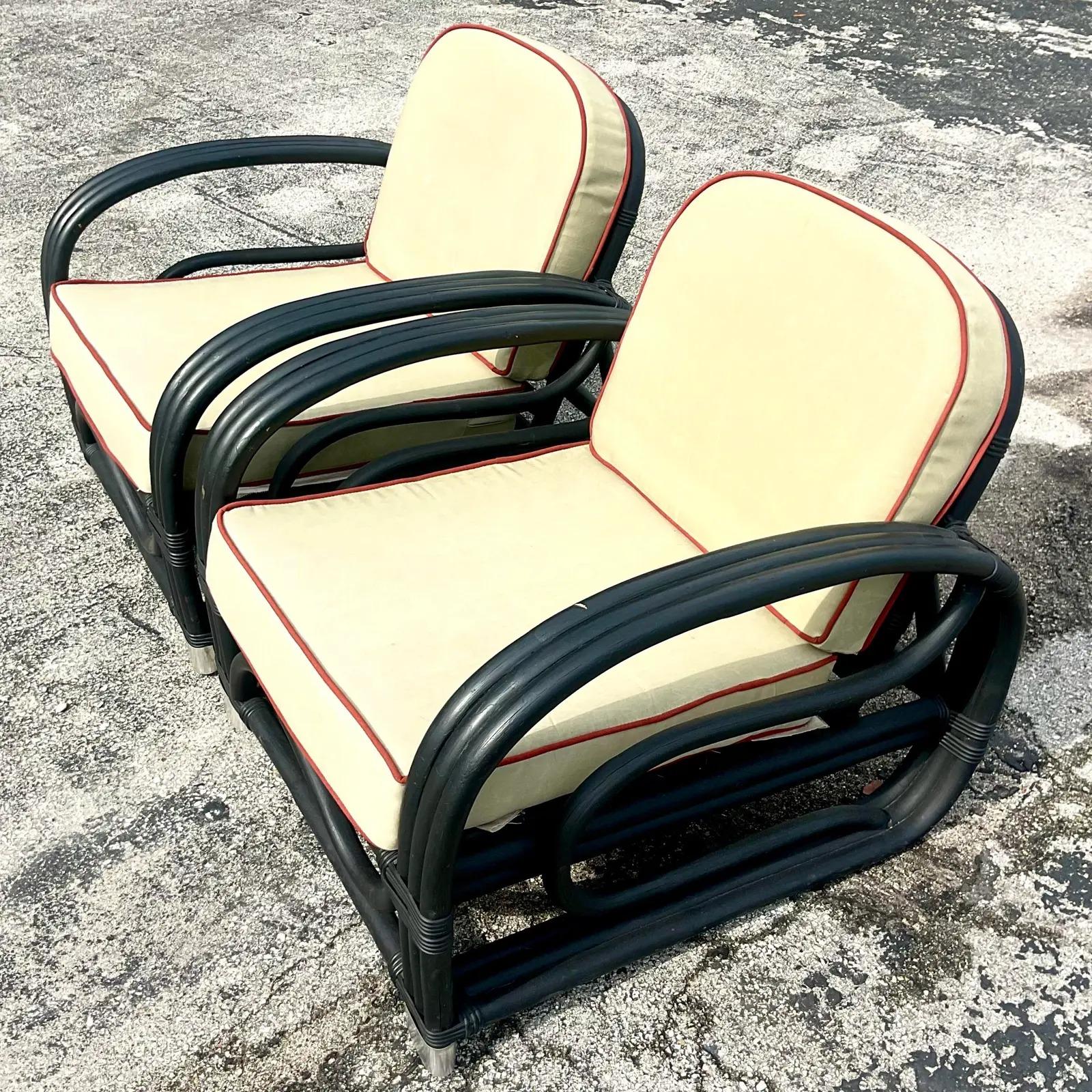 A fabulous pair of vintage Coastal lounge chairs. Beautiful bent rattan painted a matte black. A chic Calvary twill tan upholstery tipped in a warm orange. Acquired from a Palm Beach estate.