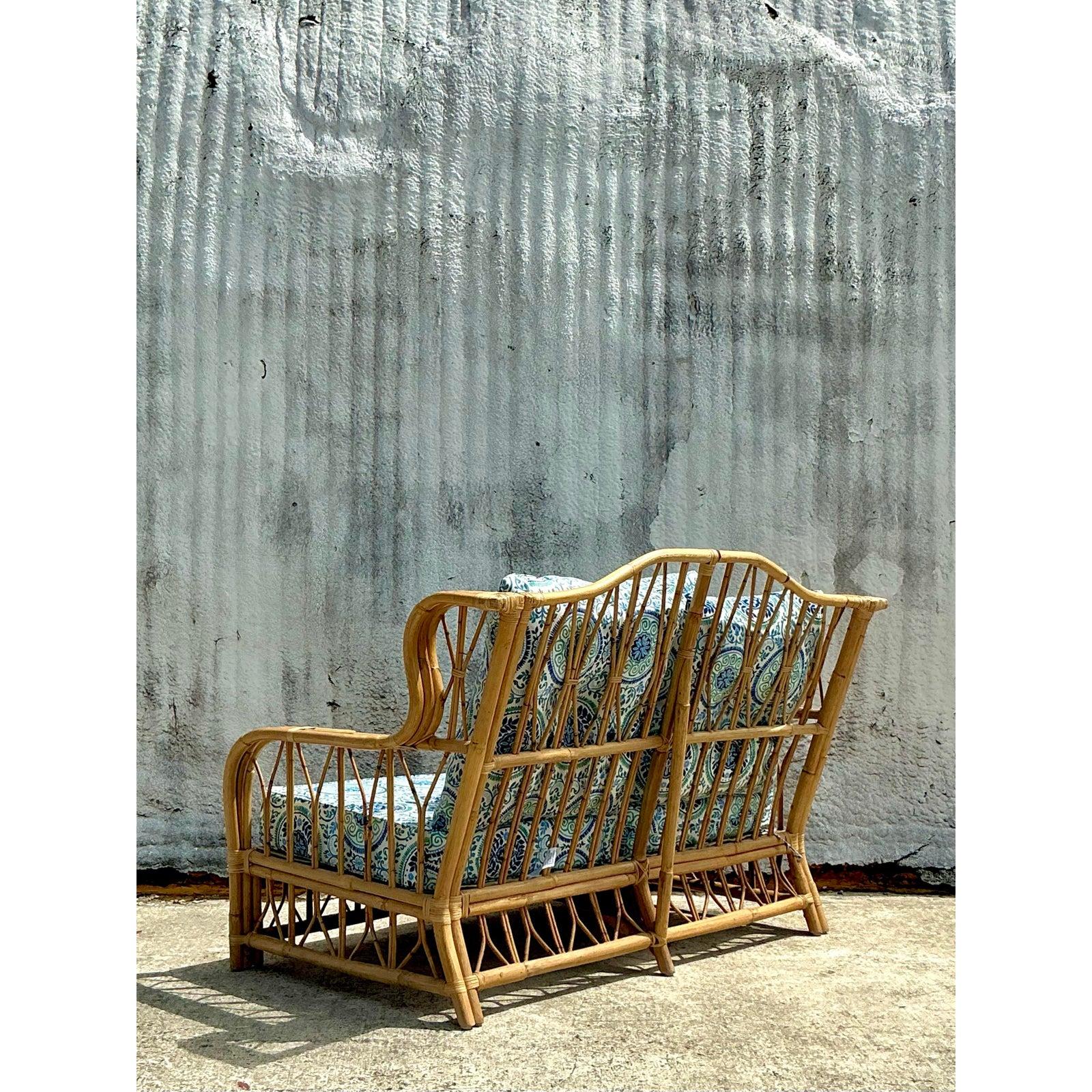 Ajoutez une touche d'élégance tropicale à votre espace avec cette causeuse vintage en rotin courbé côtier. Fabriqué à la main avec un cadre aéré à tissage ouvert, ce meuble exsude une sophistication décontractée, parfaite pour les intérieurs