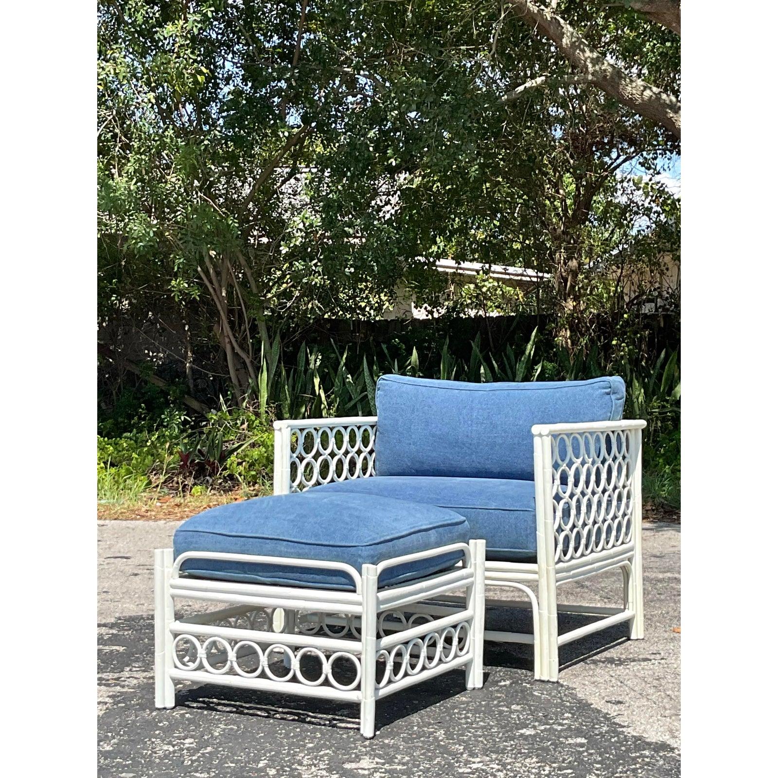 Entspannen Sie sich mit diesem charmanten Vintage-Loungesessel im Küstenstil und dem dazugehörigen Ottomanen-Set. Beide Stücke bestehen aus einem robusten Rattanrahmen, der in frischem Weiß lackiert ist und durch das charakteristische Rattangeflecht