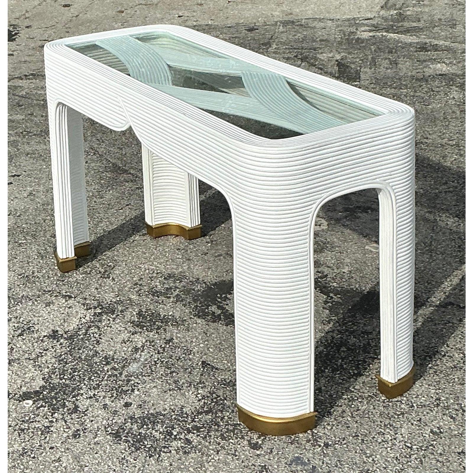Élevez votre espace avec cette table console vintage côtière en roseau, présentant un design magnifiquement texturé avec des courbes élégantes et des détails raffinés. Fabriquée avec du rotin de roseau méticuleusement enroulé, cette table incarne