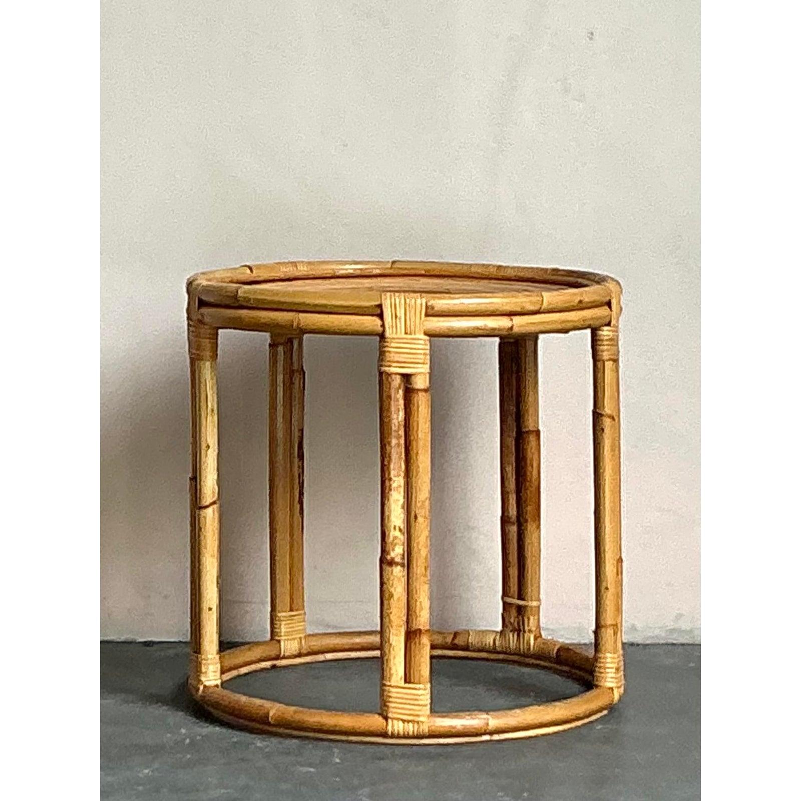 Porta un tocco di ventilata eleganza nel tuo spazio con questo tavolino vintage a spirale in giunco. Realizzato a mano con un bellissimo piano in giunco avvolto a spirale e una robusta struttura in bambù, questo affascinante pezzo incarna il fascino