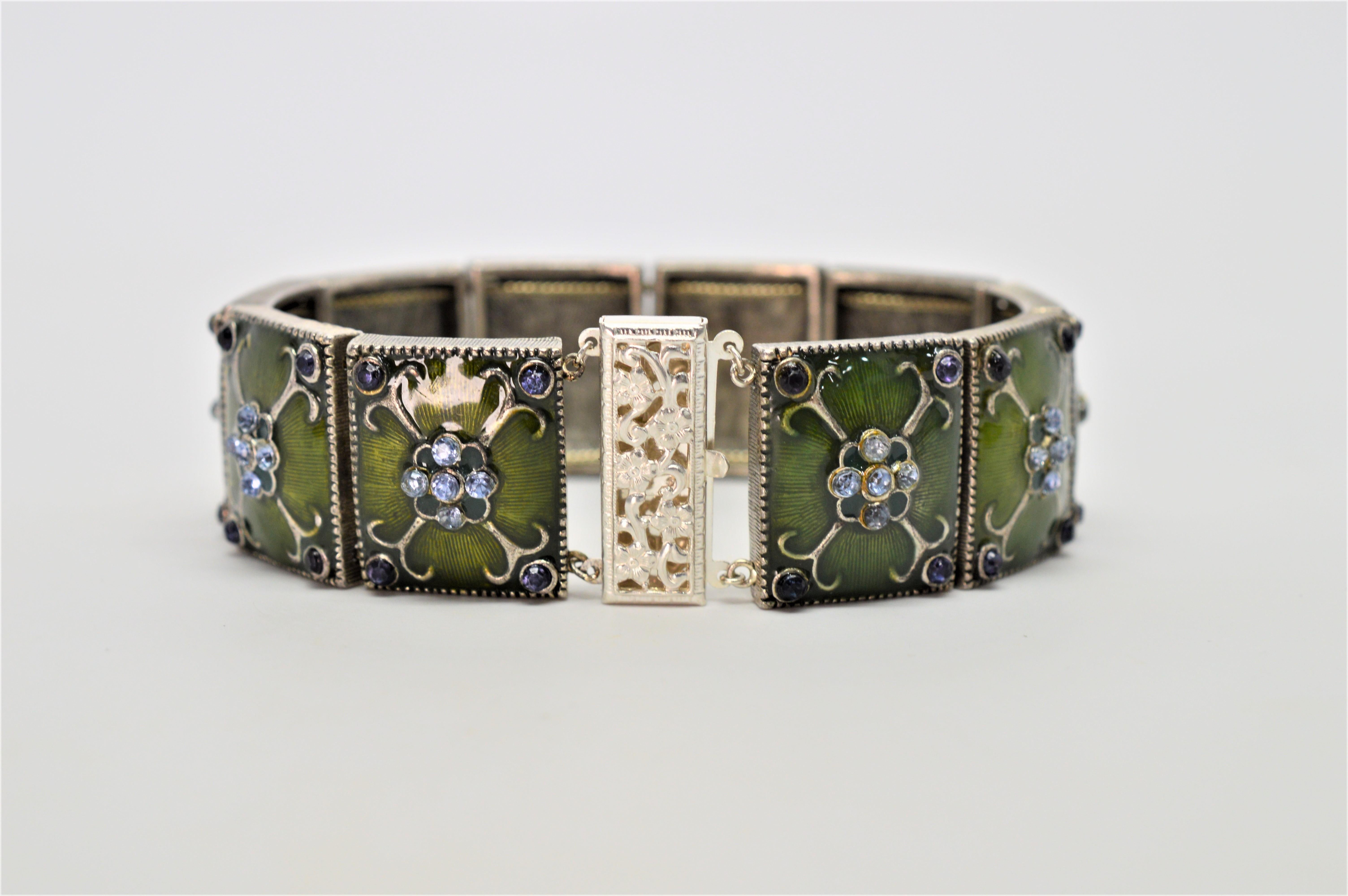 A distinct vintage piece, restored to its original vibrancy consisting of 10 moss green enamel base metal tiles linked to form this 7-1/2 inch bracelet.
Each tile link is artfully decorated with silver-tone scroll work accented with complimenting