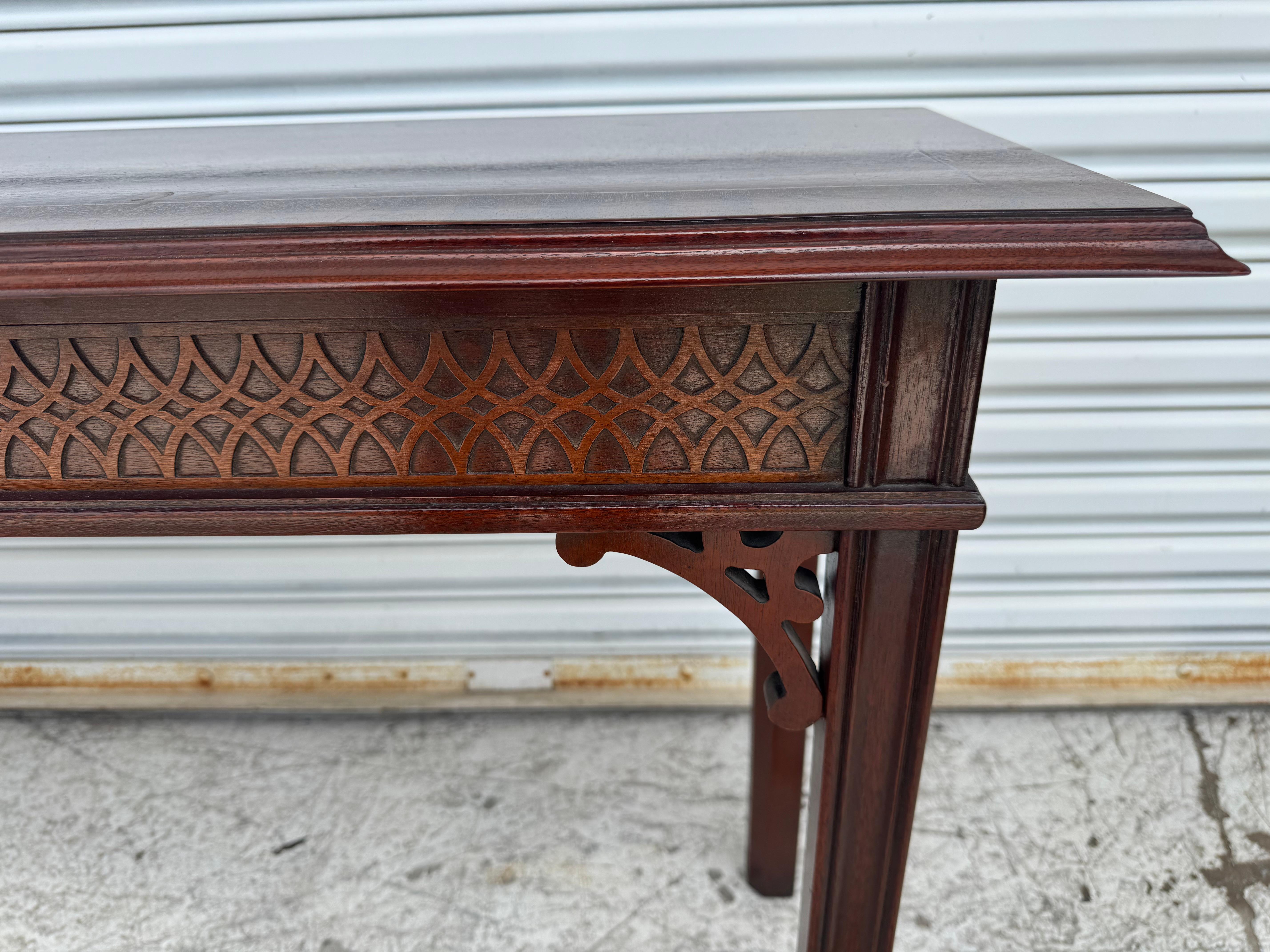 Se trata de una consola de caoba finamente elaborada por el Consejo.
Fabricado por el Consejo, tiene grecas en los conectores de las patas y 
encaje a lo largo del faldón de la mesa. Las patas son de estilo Chippendale.