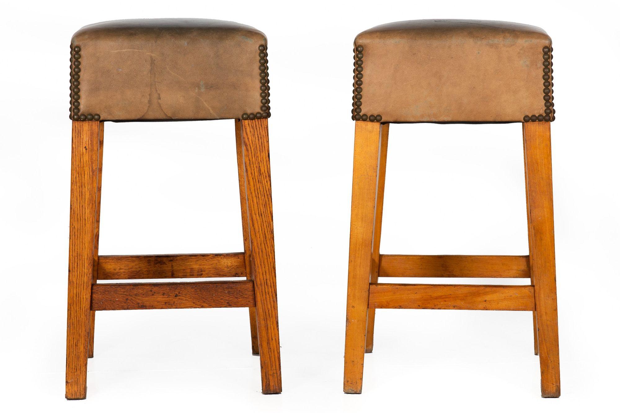 VINTAGE PAIR OF OAK AND CHERRY WORN LEATHER BARSTOOLS
Circa 2nd quarter of the 20th century  counter height
Item # 305GTP10P 

A fantastic pair of vintage barstools, they retain a very early worn leather surface with brass tacking. One is executed