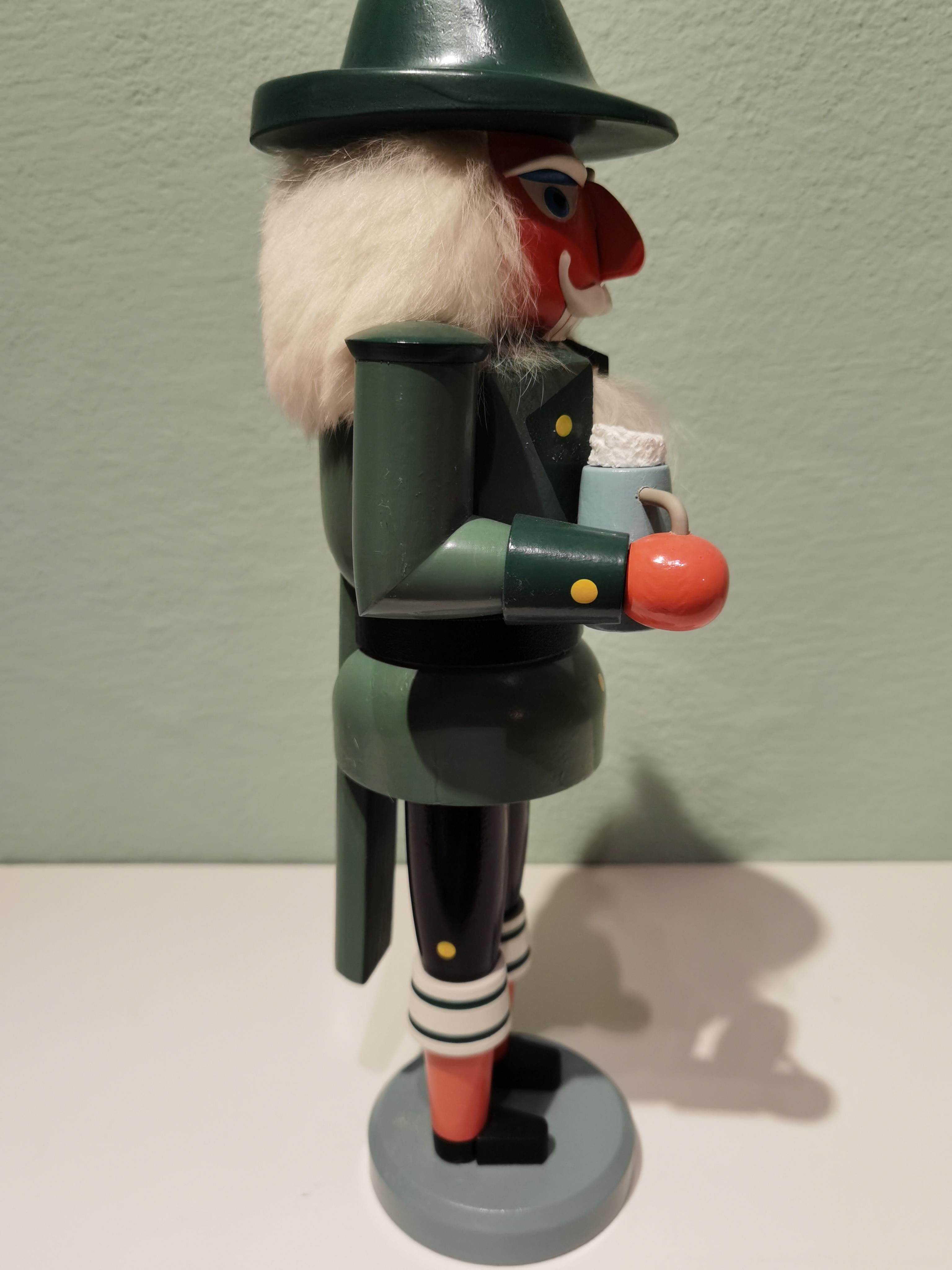 Large vintage wooden nutcracker figure from the Erzgebirge. The region Erzgebirge formerly eastern Germany is famous for this special kind of nutcrackers where intricate carving has been their home. Completely hand painted in bright green colors and