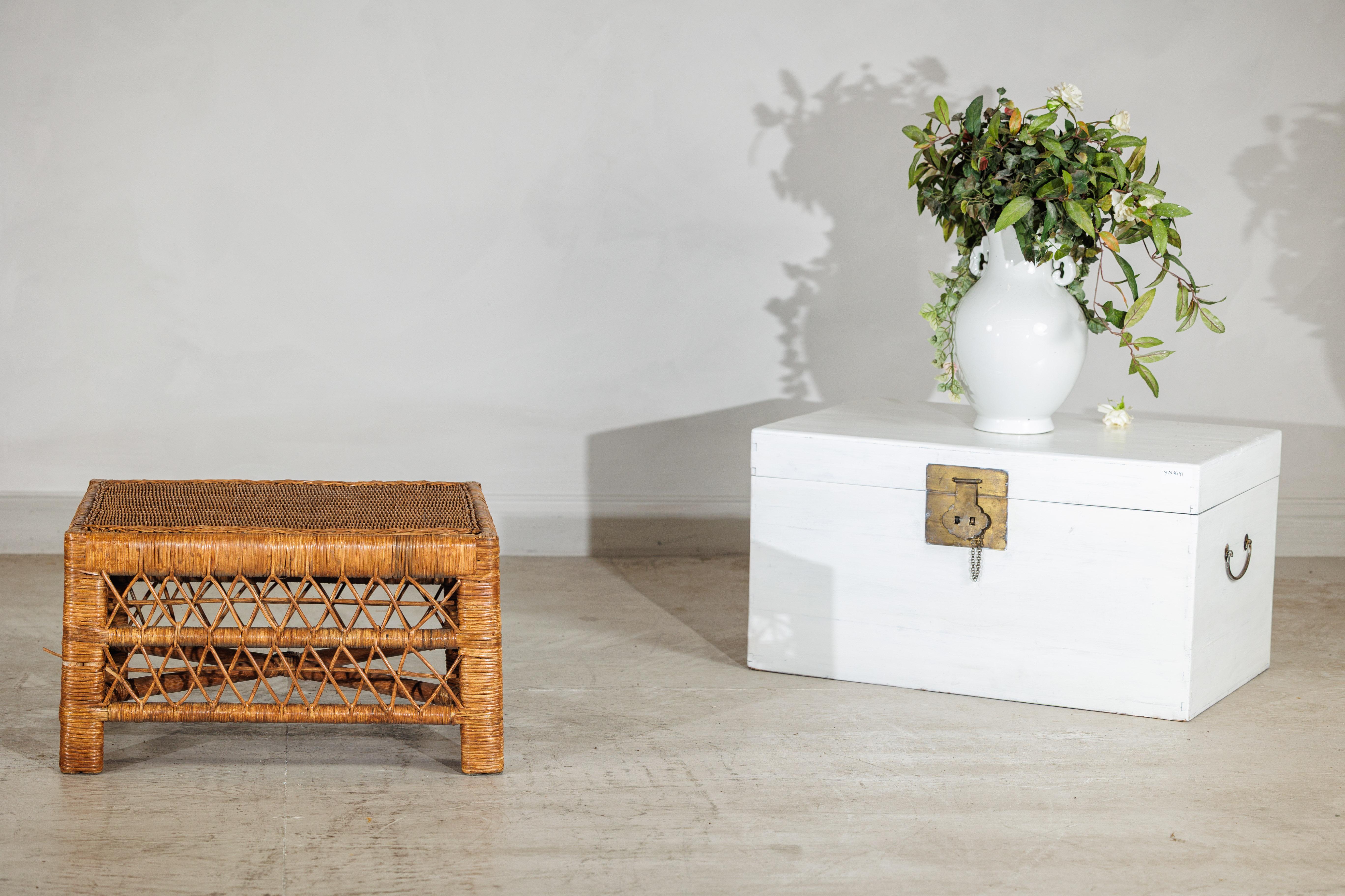 This vintage rattan coffee table offers a breezy, textural presence with its low rectangular form and handwoven latticework. Designed with a tight woven top and open diamond-pattern sides, the piece sits at just 14 inches high—making it ideal as a