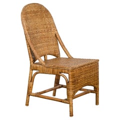 Silla vintage de ratán con respaldo inclinado y faldón delantero largo