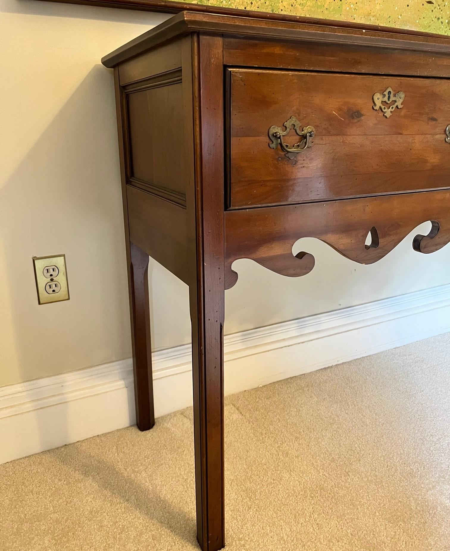 Vintage Wright Table Company George III-style Yew wood two drawer sideboard credenza with brass drawer pulls and escutcheons.  A lovely wooden furniture piece with charming details including carved elements below the drawers and on the 2